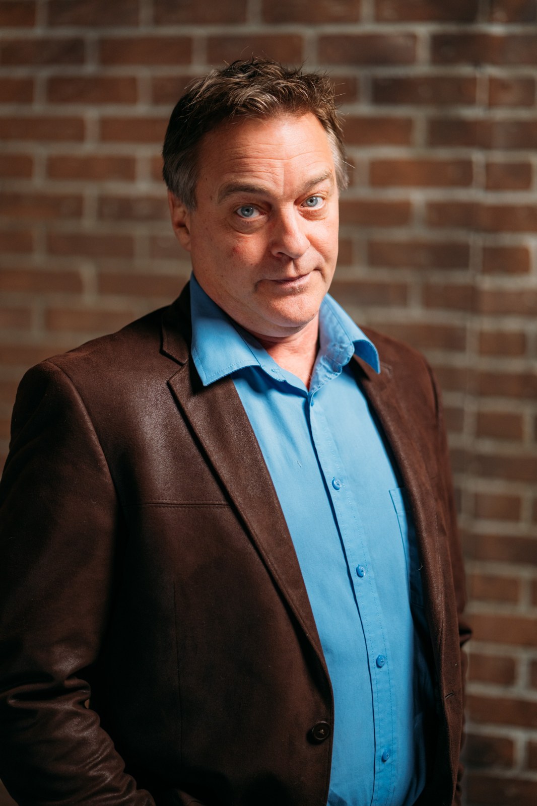 Roark Critchlow in a blue shirt and brown jacket, photographed by James Alton