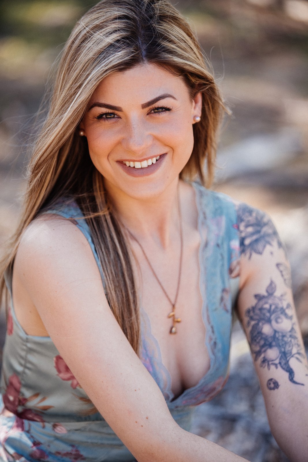 Sophia smiling beside the lake in a floral dress