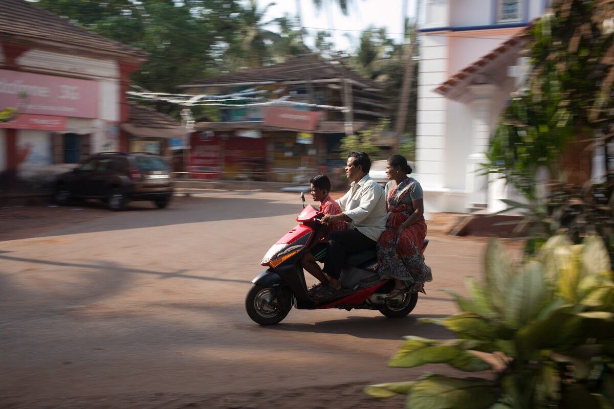A family rides a scooter through Mysore, also known as Mysuru, India. print option