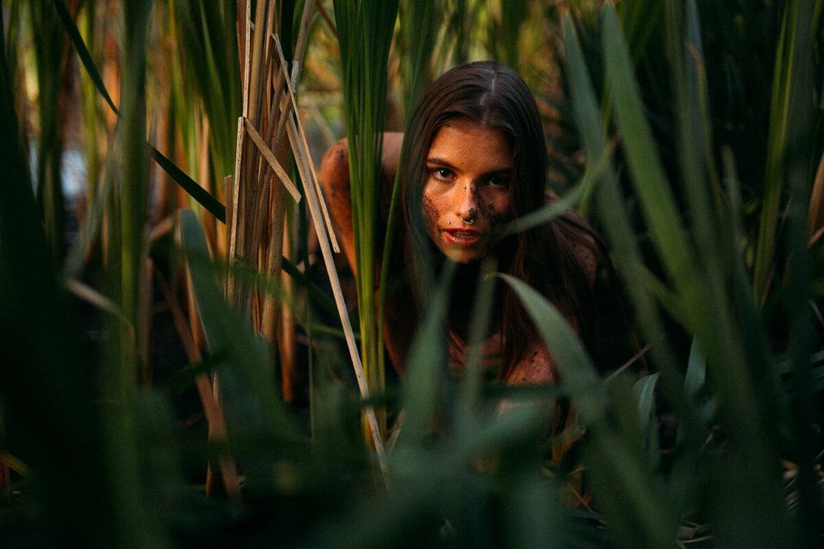 Mo in the Reeds story frame 3: A 2019 portrait archive story in reeds, body paint, low sun and green shadow.