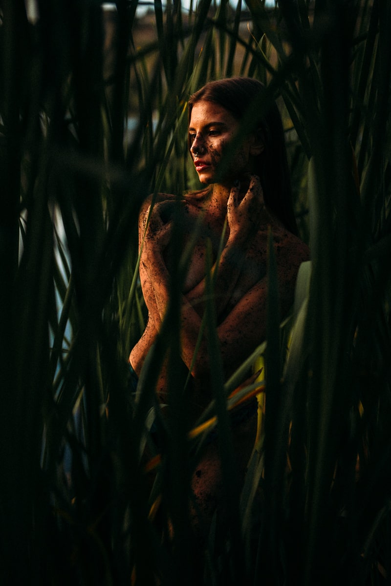 Mo in the Reeds story frame 7: A 2019 portrait archive story in reeds, body paint, low sun and green shadow.