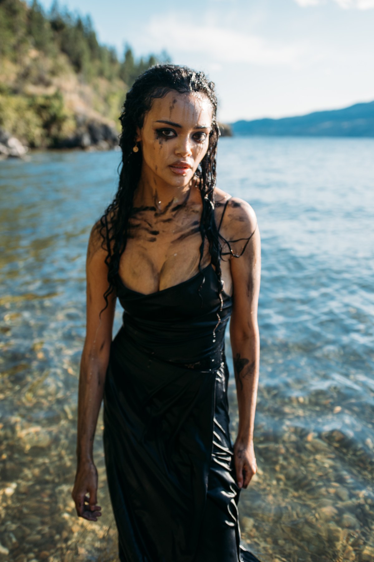 Alex by the Lake portraits story frame 8: Okanagan Lake portraits in Kelowna with black summer styling, rock, water, wind, direct expression and a cinematic beauty-portrait edge.