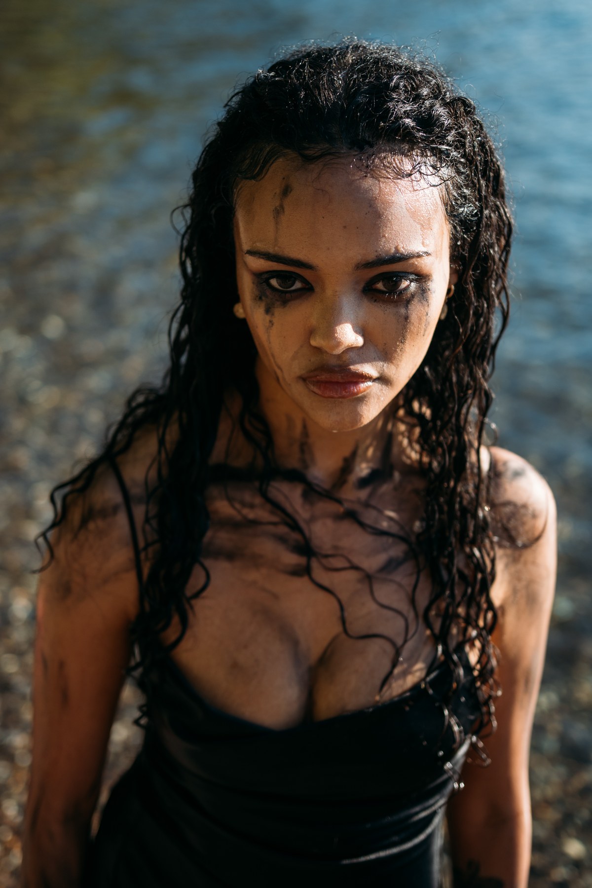 Alex by the Lake portraits story frame 10: Okanagan Lake portraits in Kelowna with black summer styling, rock, water, wind, direct expression and a cinematic beauty-portrait edge.