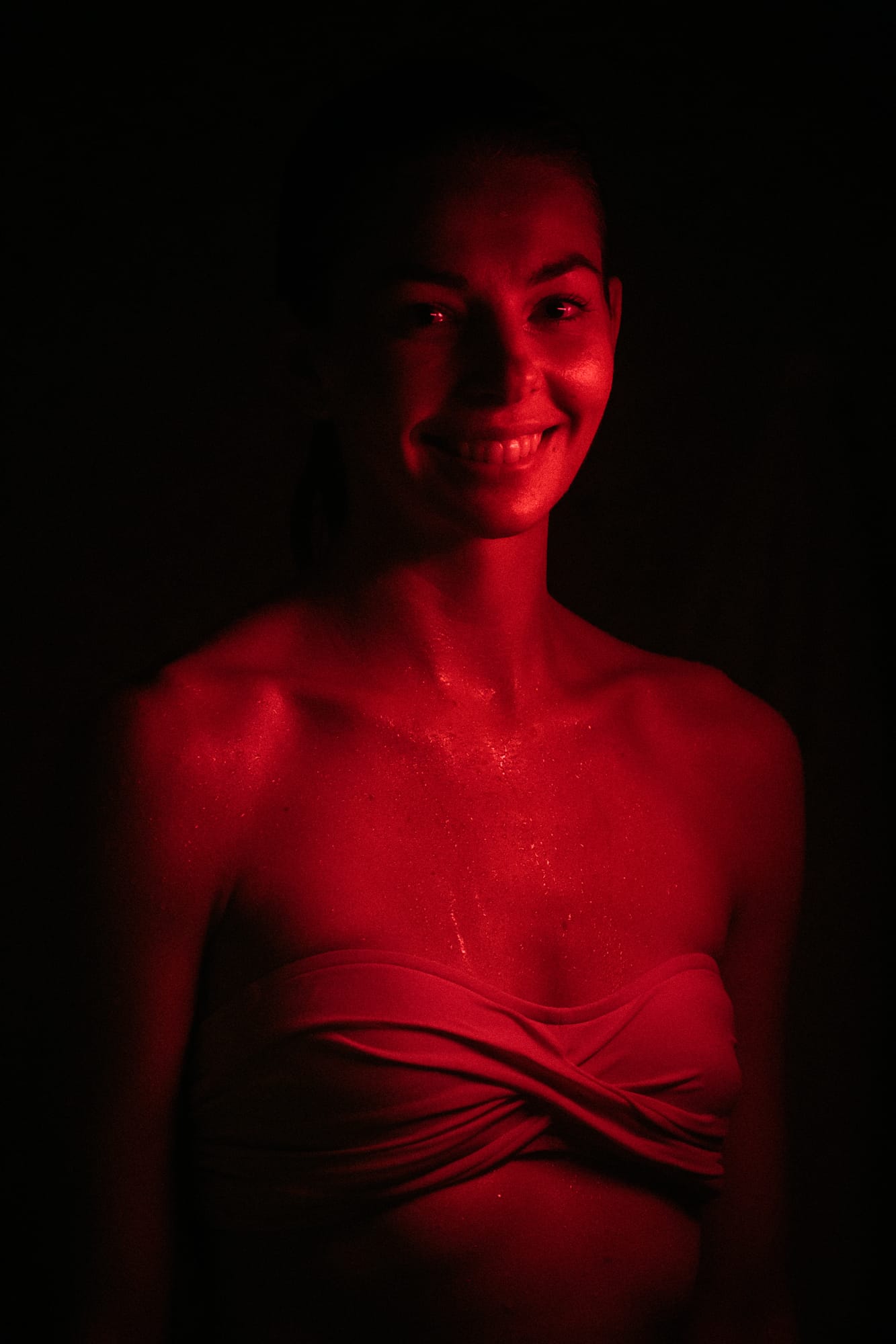 Angela at Float Space portraits story frame 14: A Float Space portrait set that moves from clean wellness headshots into red low-key portraits, skin, shadow and close detail..