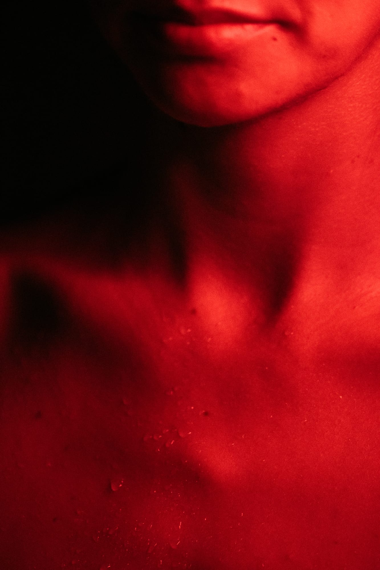 Angela at Float Space portraits story frame 18: A Float Space portrait set that moves from clean wellness headshots into red low-key portraits, skin, shadow and close detail..