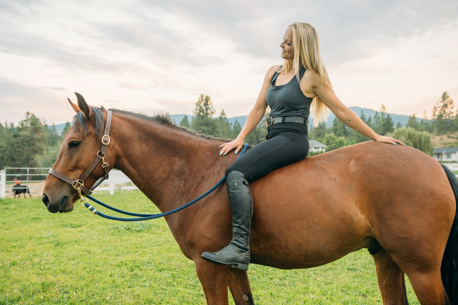 Ashton at the Ranch portraits story frame 5: Ranch portraits for Ashton in Kelowna, with horses, open pasture, quiet country styling and Okanagan light shaped into a grounded portrait story.
