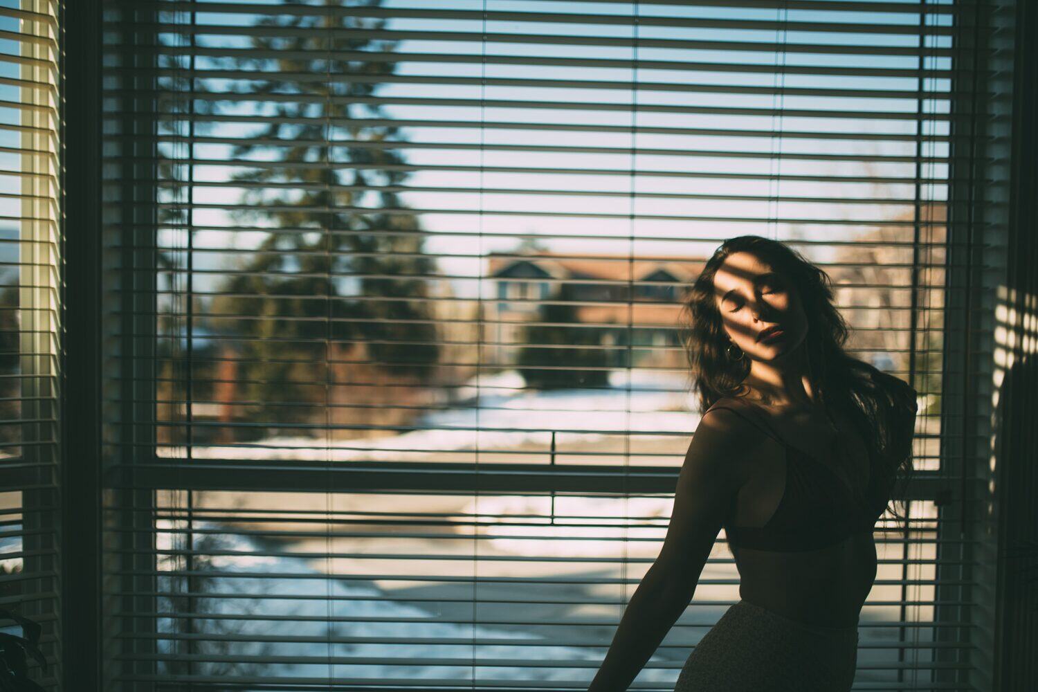 Bailey in Kelowna portraits story frame 7: Two portrait sessions with Bailey in Kelowna: window light, body line and bold colour on March 12, followed by pale and black styling, foliage, and daylight and candlelit floral-bath portraits on March 19.