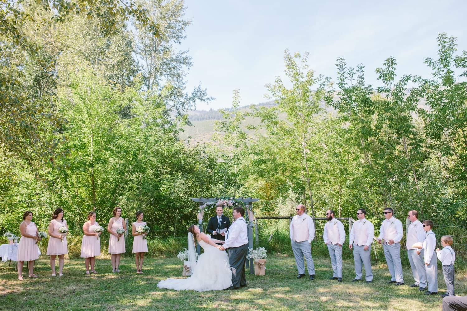 Barbara and Ryan weddings story frame 21: A Salmon Arm wedding near Mount Ida, moving from a private yard to Marine Peace Park and wharf portraits, with the groom's trucking life part of the story..