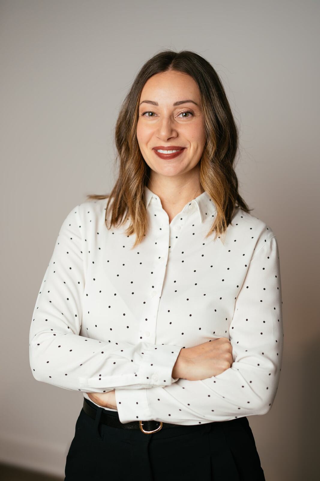 Beth with folded arms in a relaxed business portrait