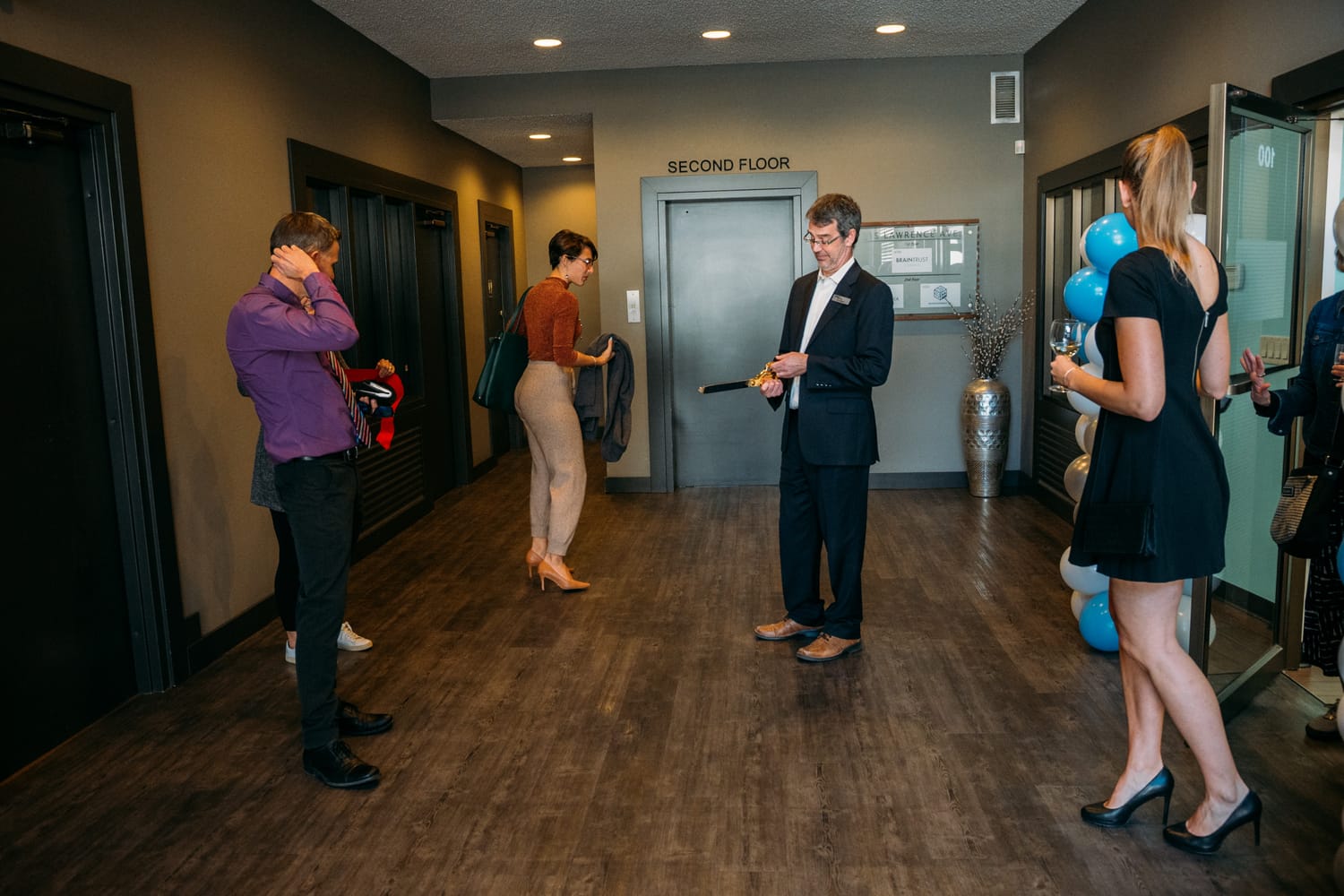 BrainTrust Canada Grand Opening corporate story frame 4: Event photography for BrainTrust Canada's Kelowna grand opening, with ribbon cutting, guests, office details, local food and exterior images for community and nonprofit communications..