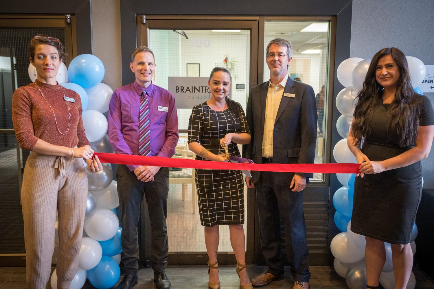 BrainTrust Canada Grand Opening corporate story frame 8: Event photography for BrainTrust Canada's Kelowna grand opening, with ribbon cutting, guests, office details, local food and exterior images for community and nonprofit communications..