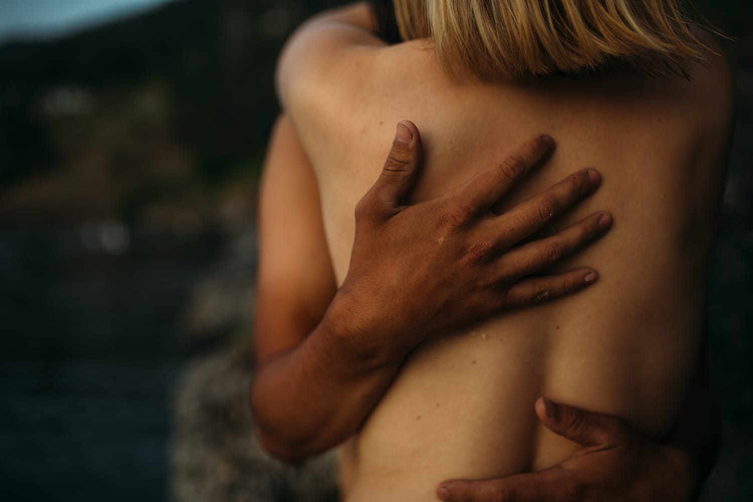 Brittany and Chris portraits story frame 5: An intimate Kelowna couples portrait study for Brittany and Chris, photographed close to the water with skin, hands, shadow and quiet connection.