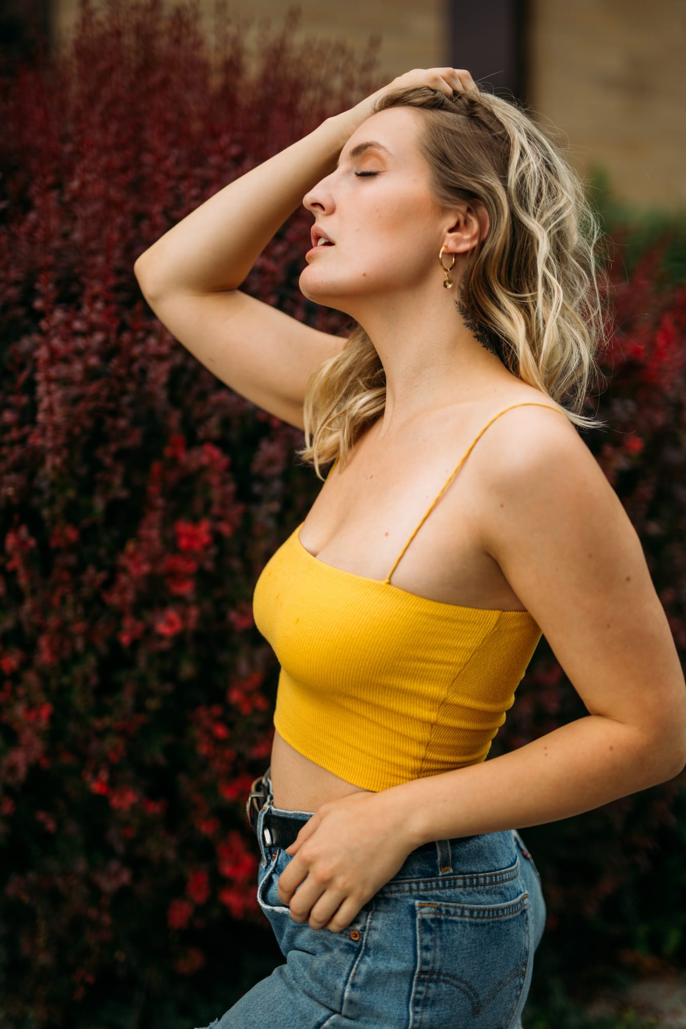 Brittany in Yellow and Blue portraits story frame 6: A two-look Kelowna portrait story for Brittany, led by the yellow styling and dark green texture, then moving into blue lakeside frames and a soft rainbow-bokeh finish.