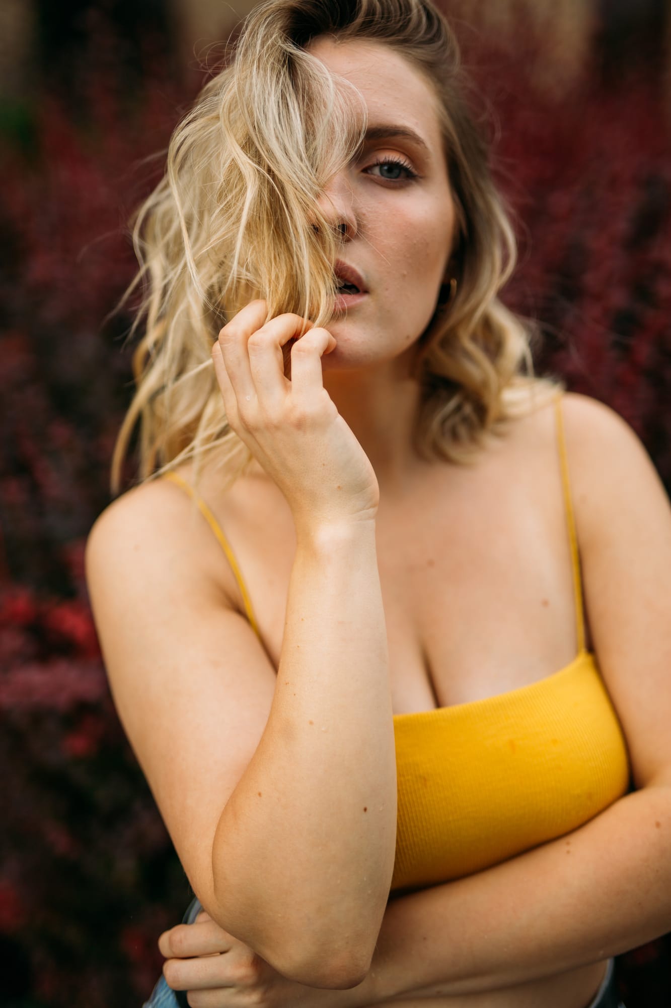 Brittany in Yellow and Blue portraits story frame 8: A two-look Kelowna portrait story for Brittany, led by the yellow styling and dark green texture, then moving into blue lakeside frames and a soft rainbow-bokeh finish.