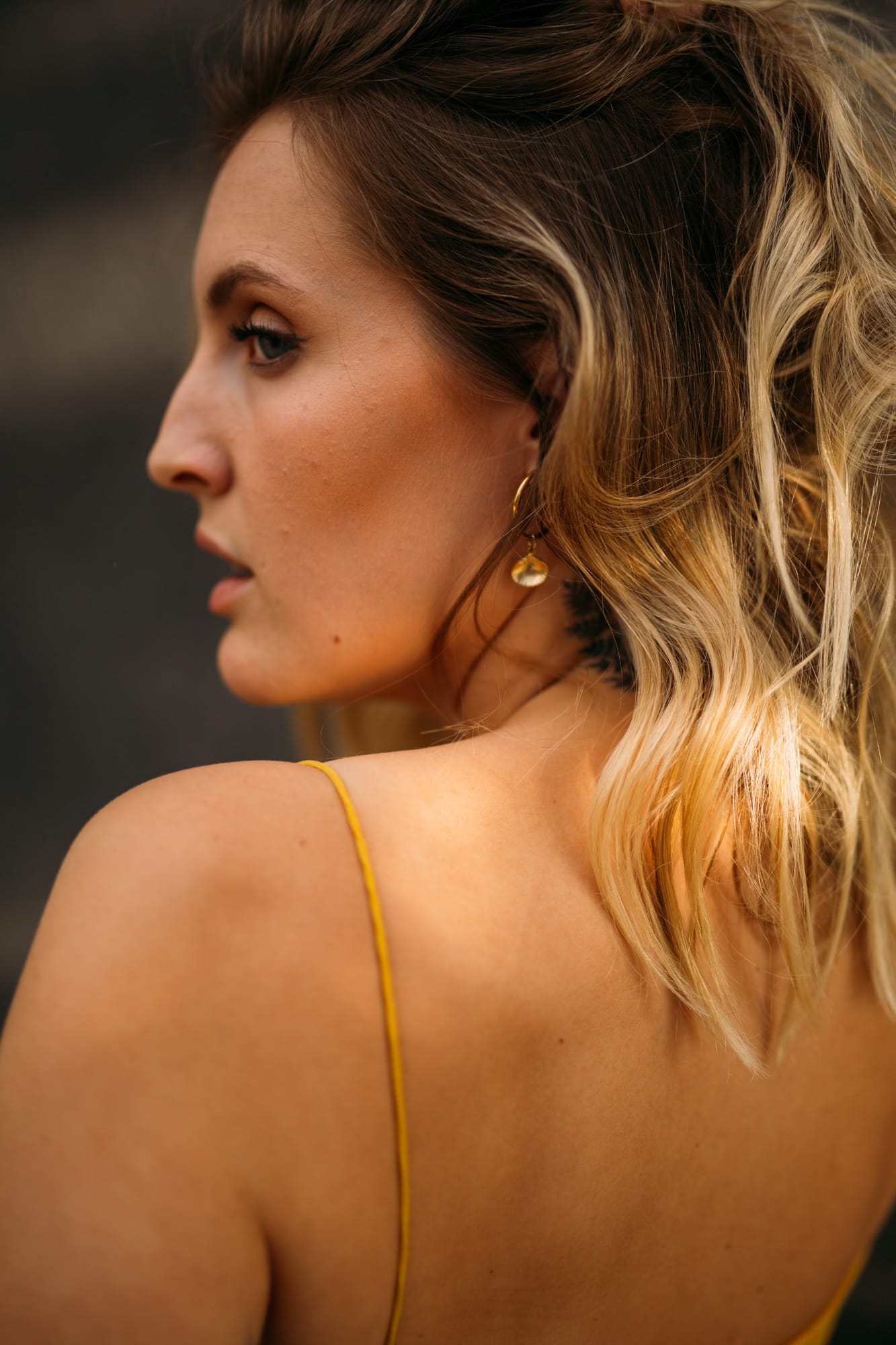 Brittany in Yellow and Blue portraits story frame 11: A two-look Kelowna portrait story for Brittany, led by the yellow styling and dark green texture, then moving into blue lakeside frames and a soft rainbow-bokeh finish.