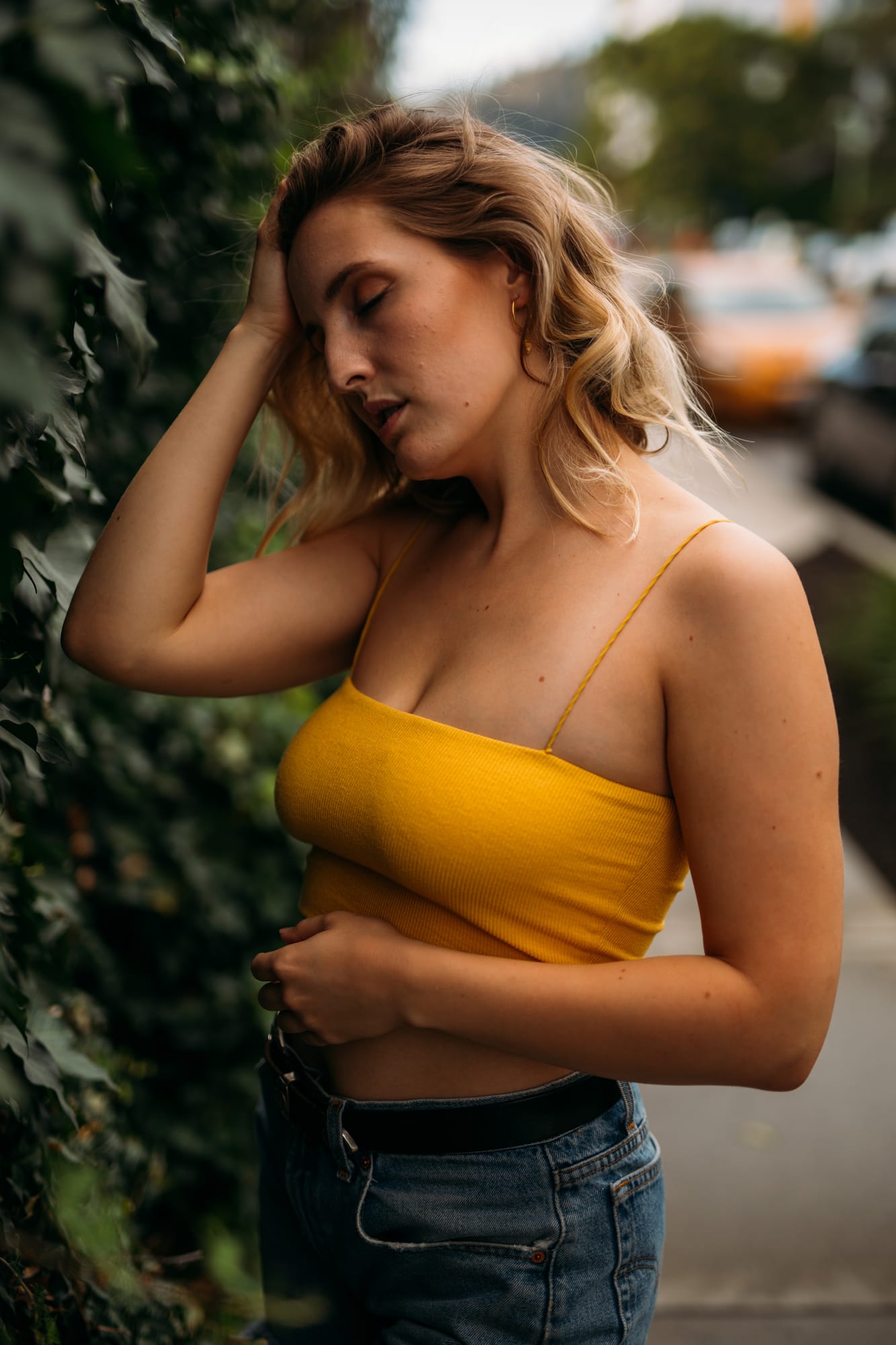 Brittany in Yellow and Blue portraits story frame 16: A two-look Kelowna portrait story for Brittany, led by the yellow styling and dark green texture, then moving into blue lakeside frames and a soft rainbow-bokeh finish.