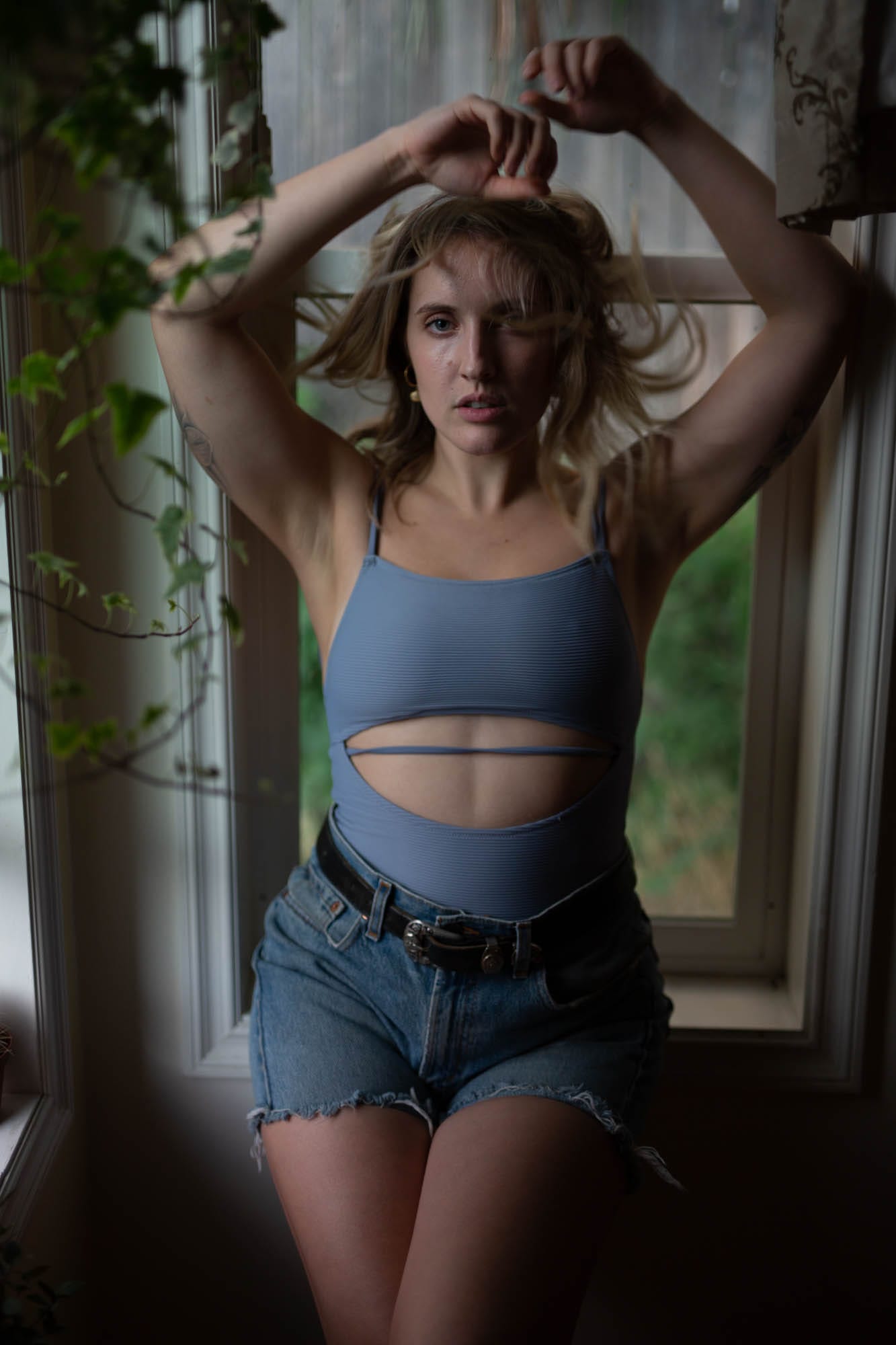 Brittany in Yellow and Blue portraits story frame 19: A two-look Kelowna portrait story for Brittany, led by the yellow styling and dark green texture, then moving into blue lakeside frames and a soft rainbow-bokeh finish.