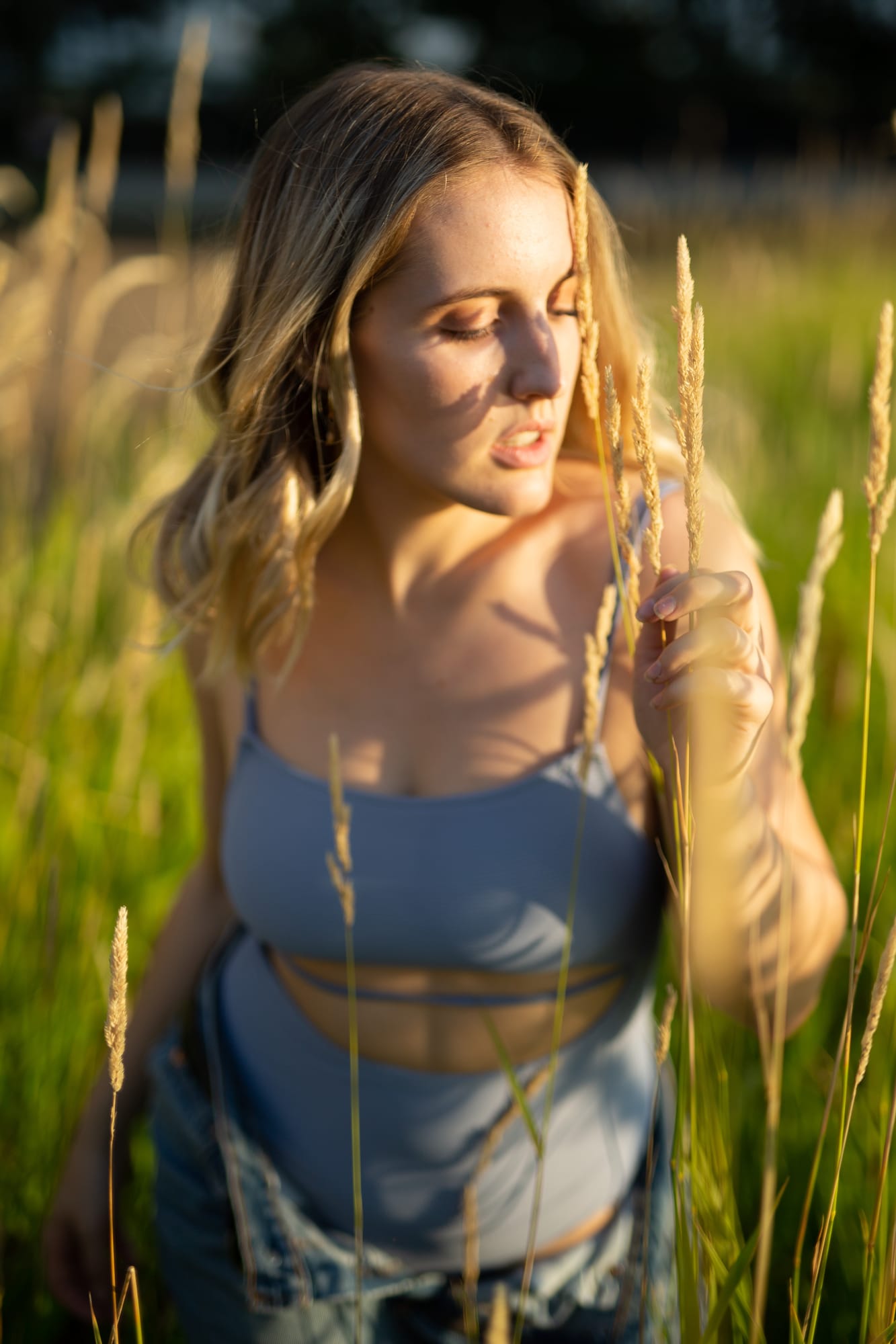 Brittany in Yellow and Blue portraits story frame 23: A two-look Kelowna portrait story for Brittany, led by the yellow styling and dark green texture, then moving into blue lakeside frames and a soft rainbow-bokeh finish.
