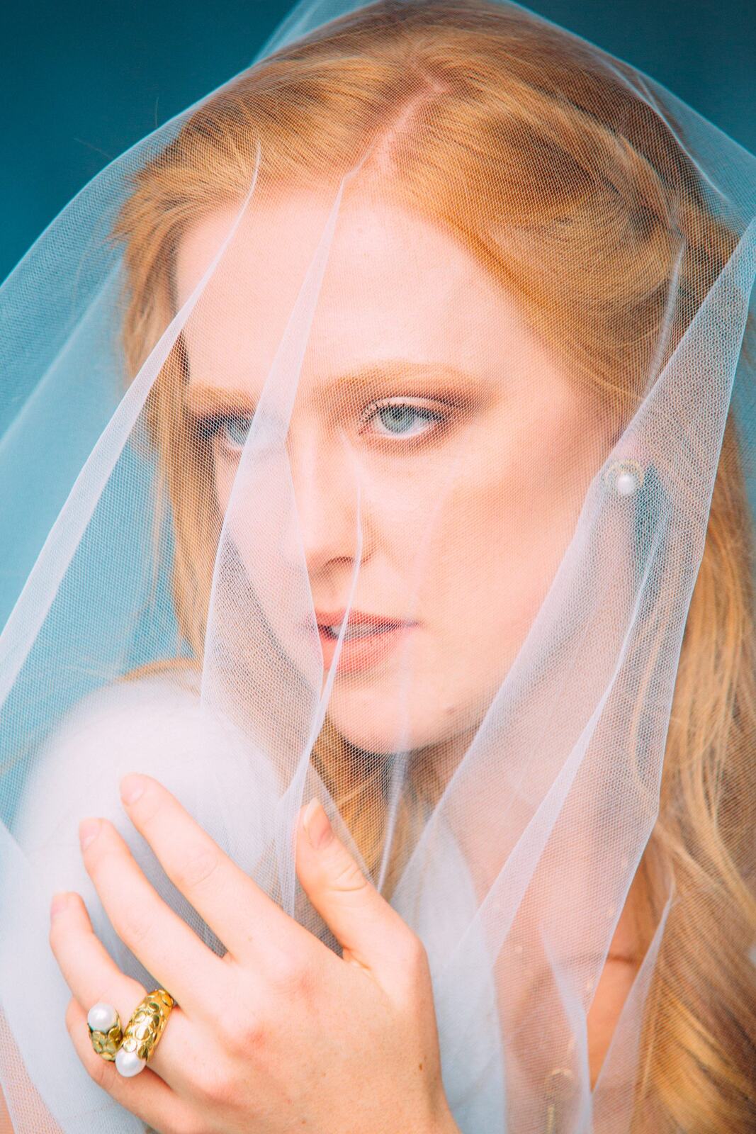 Catherine portraits story frame 8: Fashion portraits with Catherine from a White Willow Photography-designed collaboration near Salmon Arm, with pale blue styling, jewellery, veil and a painted studio backdrop.
