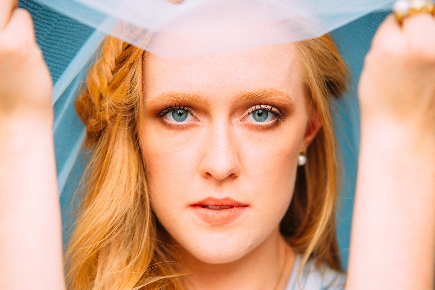 Catherine portraits story frame 16: Fashion portraits with Catherine from a White Willow Photography-designed collaboration near Salmon Arm, with pale blue styling, jewellery, veil and a painted studio backdrop.