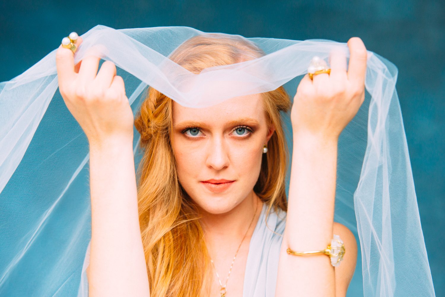 Catherine portraits story frame 17: Fashion portraits with Catherine from a White Willow Photography-designed collaboration near Salmon Arm, with pale blue styling, jewellery, veil and a painted studio backdrop.