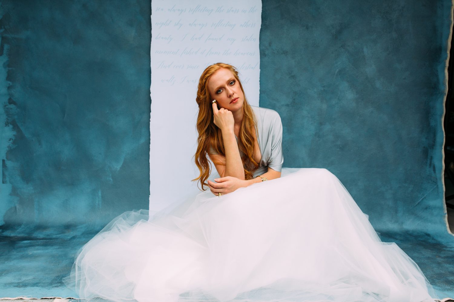 Catherine portraits story frame 18: Fashion portraits with Catherine from a White Willow Photography-designed collaboration near Salmon Arm, with pale blue styling, jewellery, veil and a painted studio backdrop.