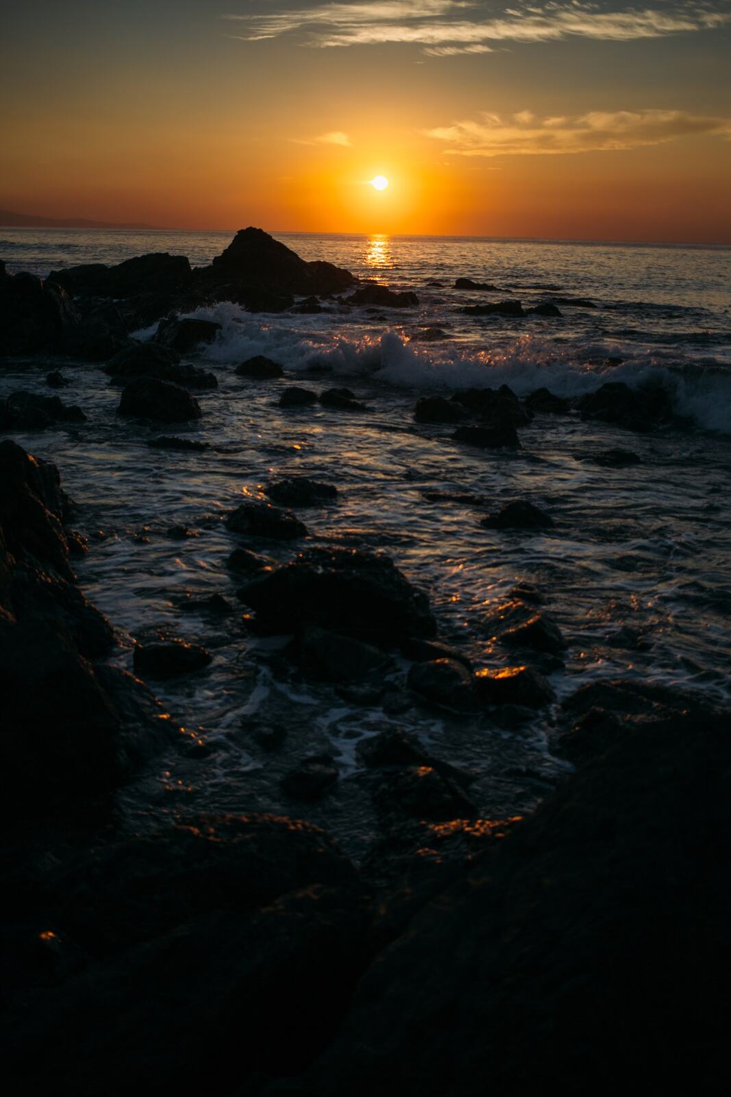 Orange sunset reflected through Costa Rica surf