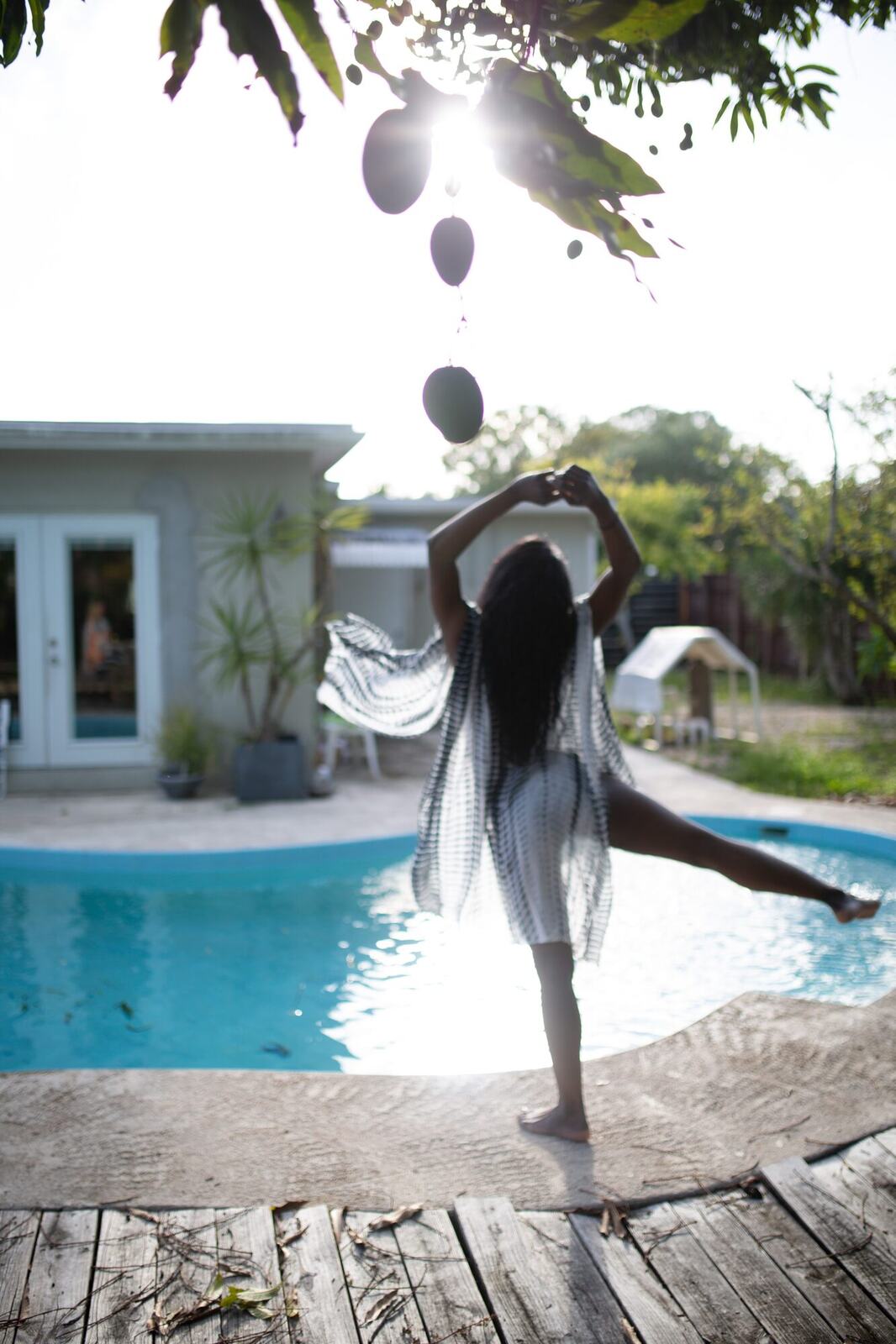 Dee-J in Miami portraits story frame 28: Two days with Dee-J in Miami, moving from a bright poolside portrait story to a second pool sequence and green-dress portraits along the riverbank.