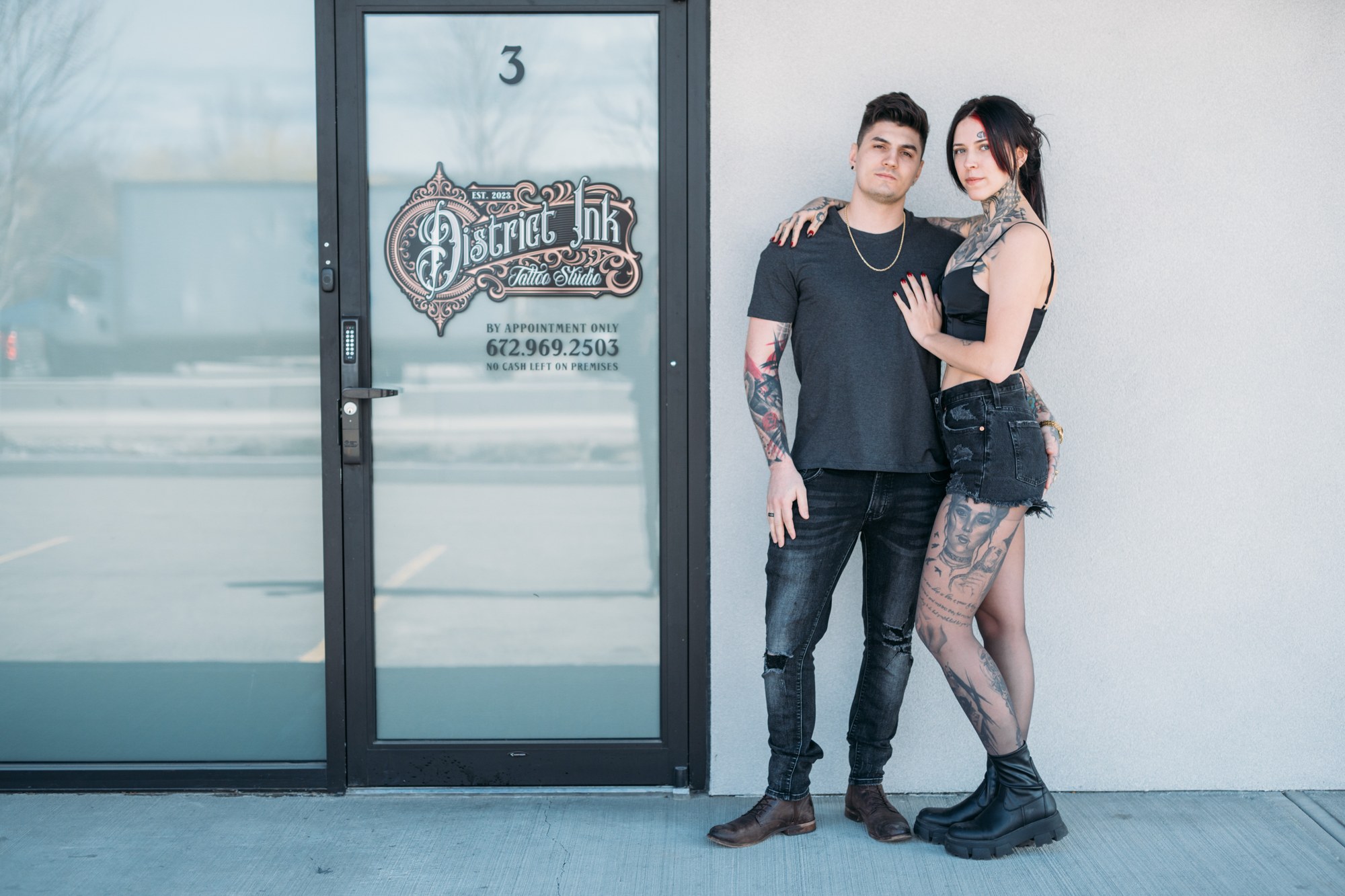 District Ink: Full team portrait beside the signed storefront.