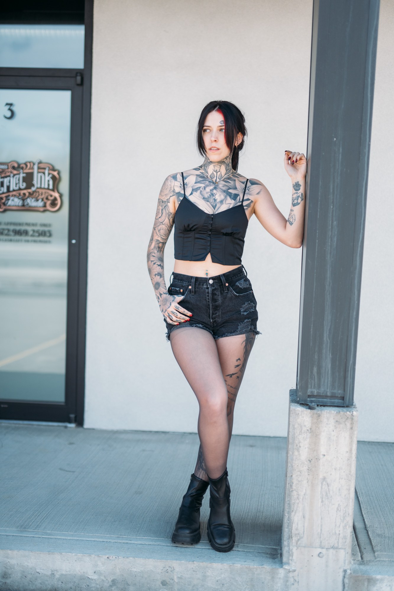 District Ink: Full-length portrait by the doorway.
