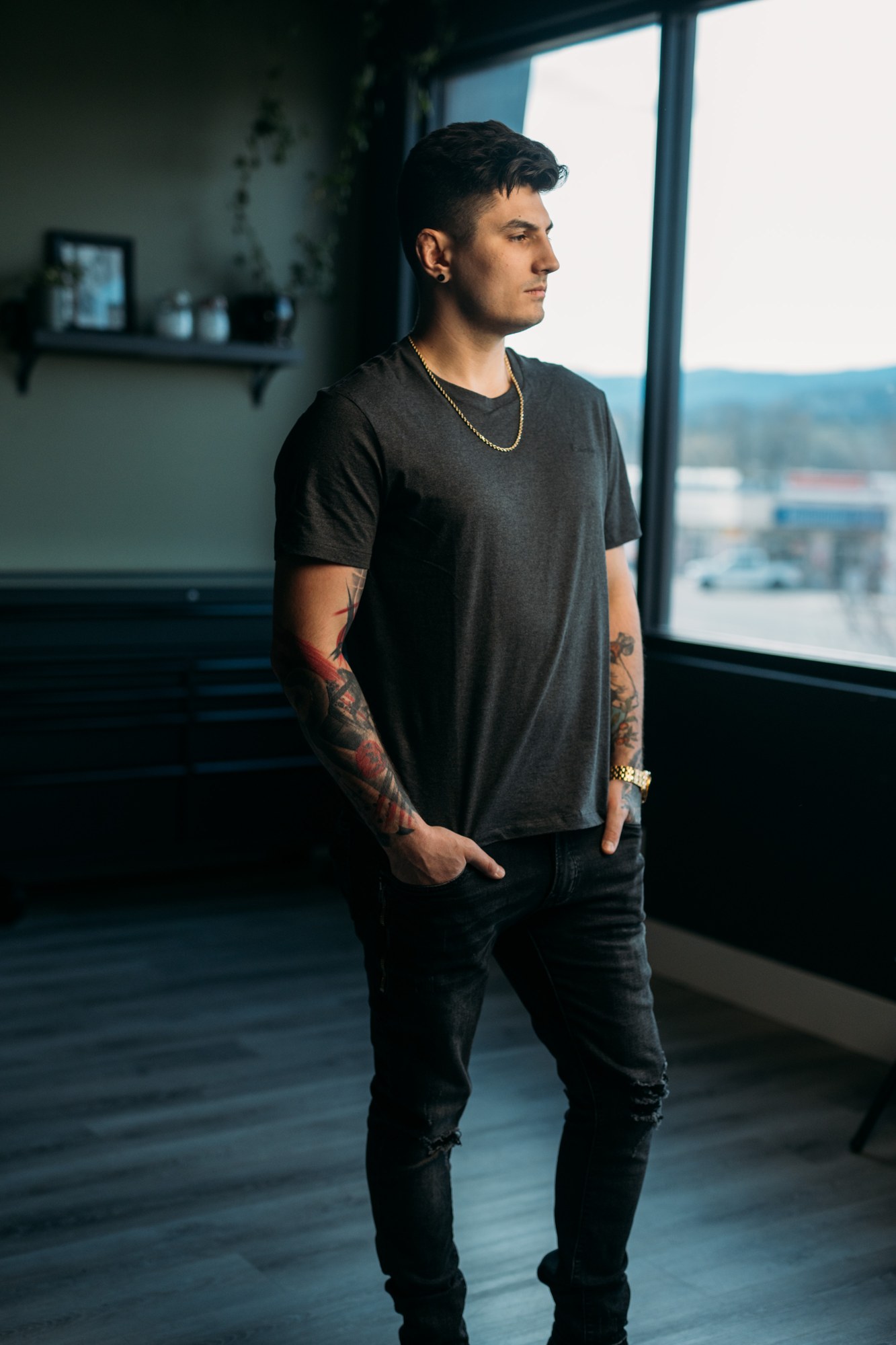 District Ink: Full standing figure beside the studio window.