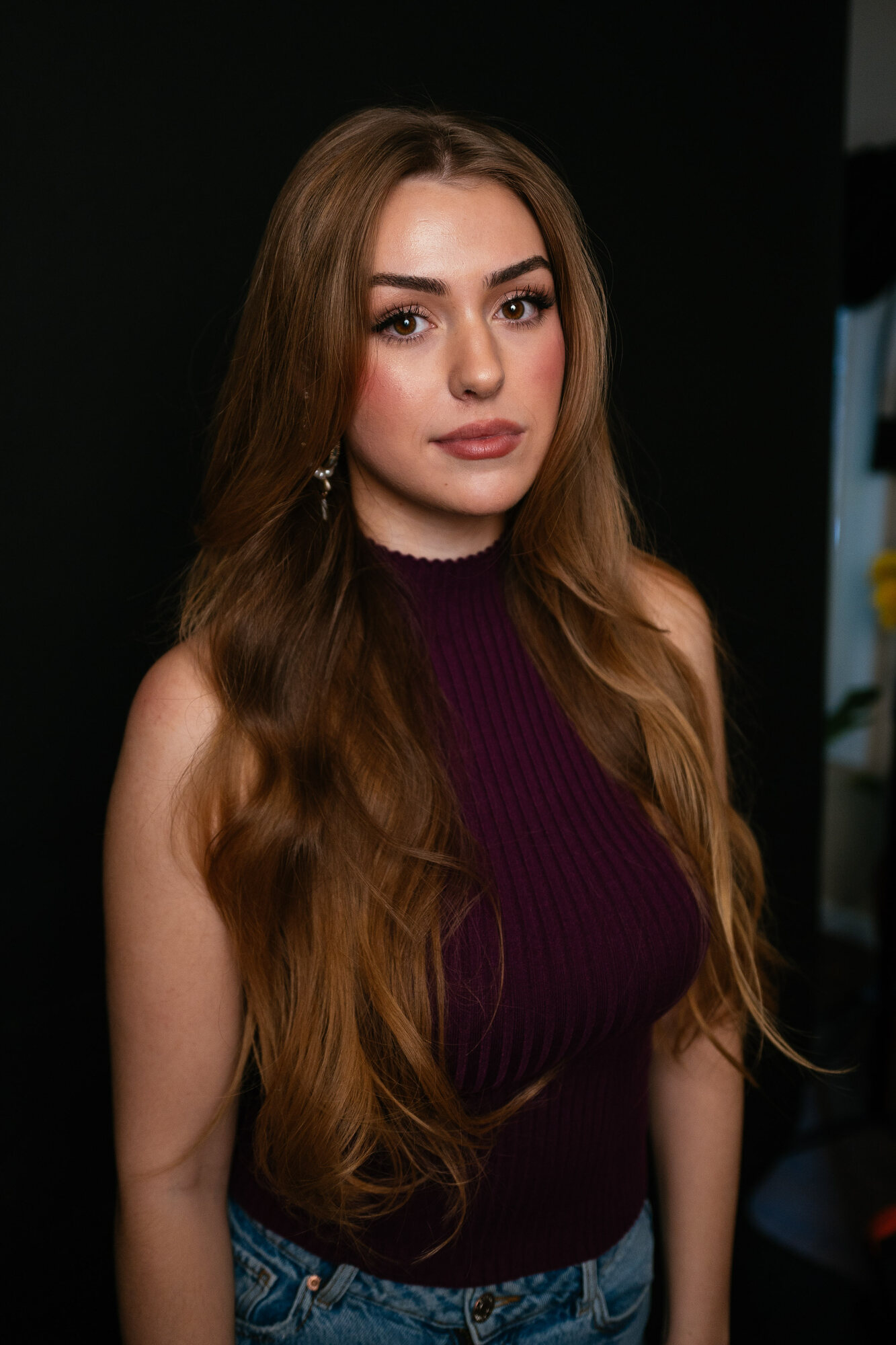 Elena black-backdrop headshot with burgundy top