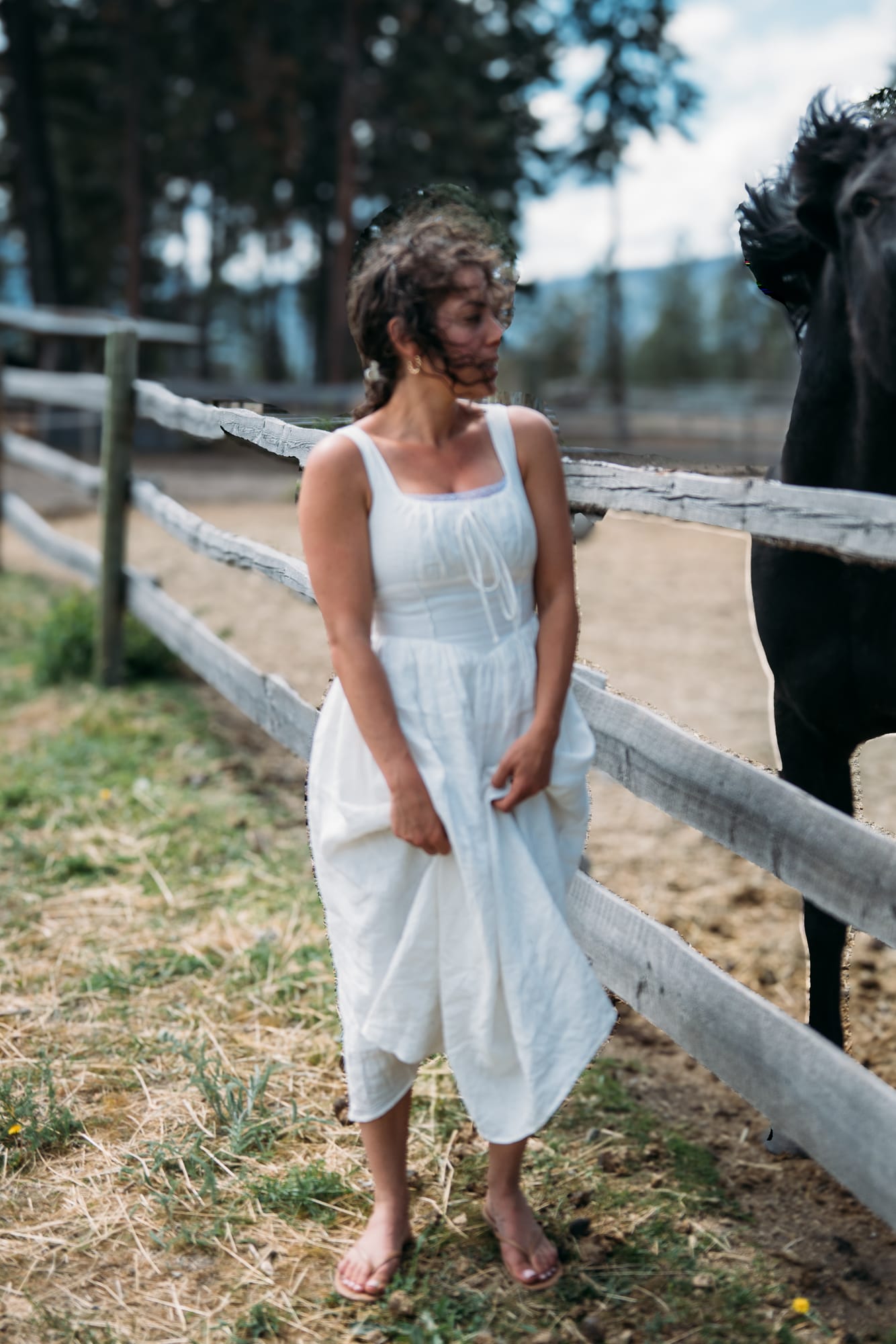Giuliana at LoveReins portraits story frame 6: Equestrian portrait session at Love Reins Ranch in Lake Country, BC, with Giuliana, horses, white-dress portraits, Western cowgirl styling, ranch fencing, riding frames and warm Okanagan light..