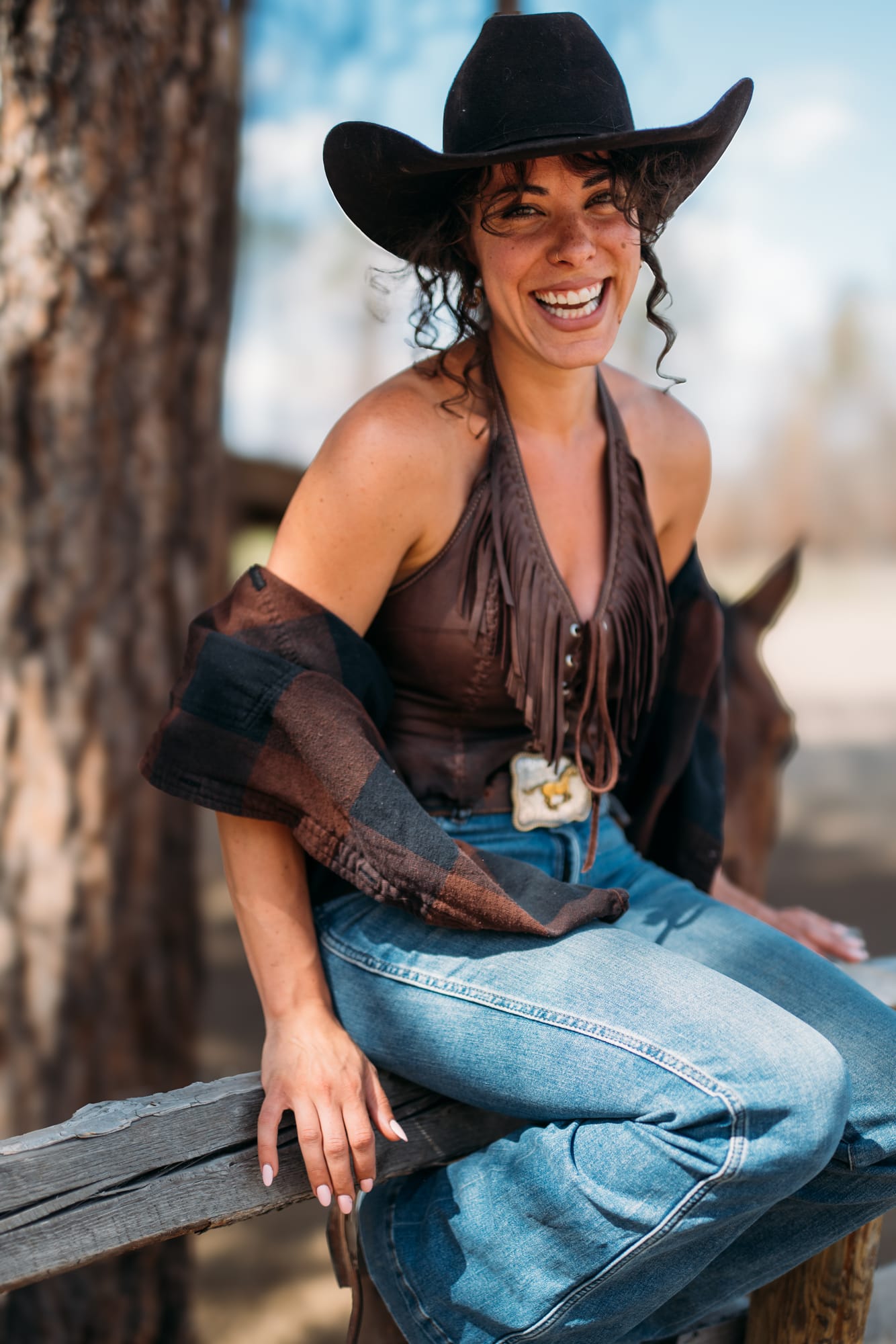 Giuliana at LoveReins portraits story frame 8: Equestrian portrait session at Love Reins Ranch in Lake Country, BC, with Giuliana, horses, white-dress portraits, Western cowgirl styling, ranch fencing, riding frames and warm Okanagan light..