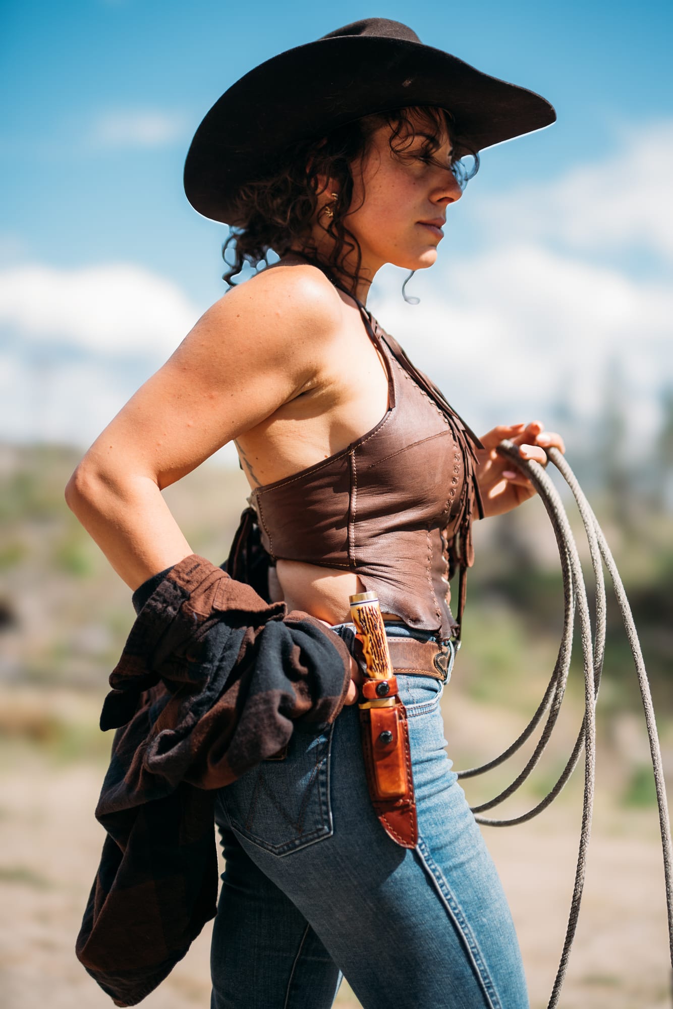 Giuliana at LoveReins portraits story frame 9: Equestrian portrait session at Love Reins Ranch in Lake Country, BC, with Giuliana, horses, white-dress portraits, Western cowgirl styling, ranch fencing, riding frames and warm Okanagan light..