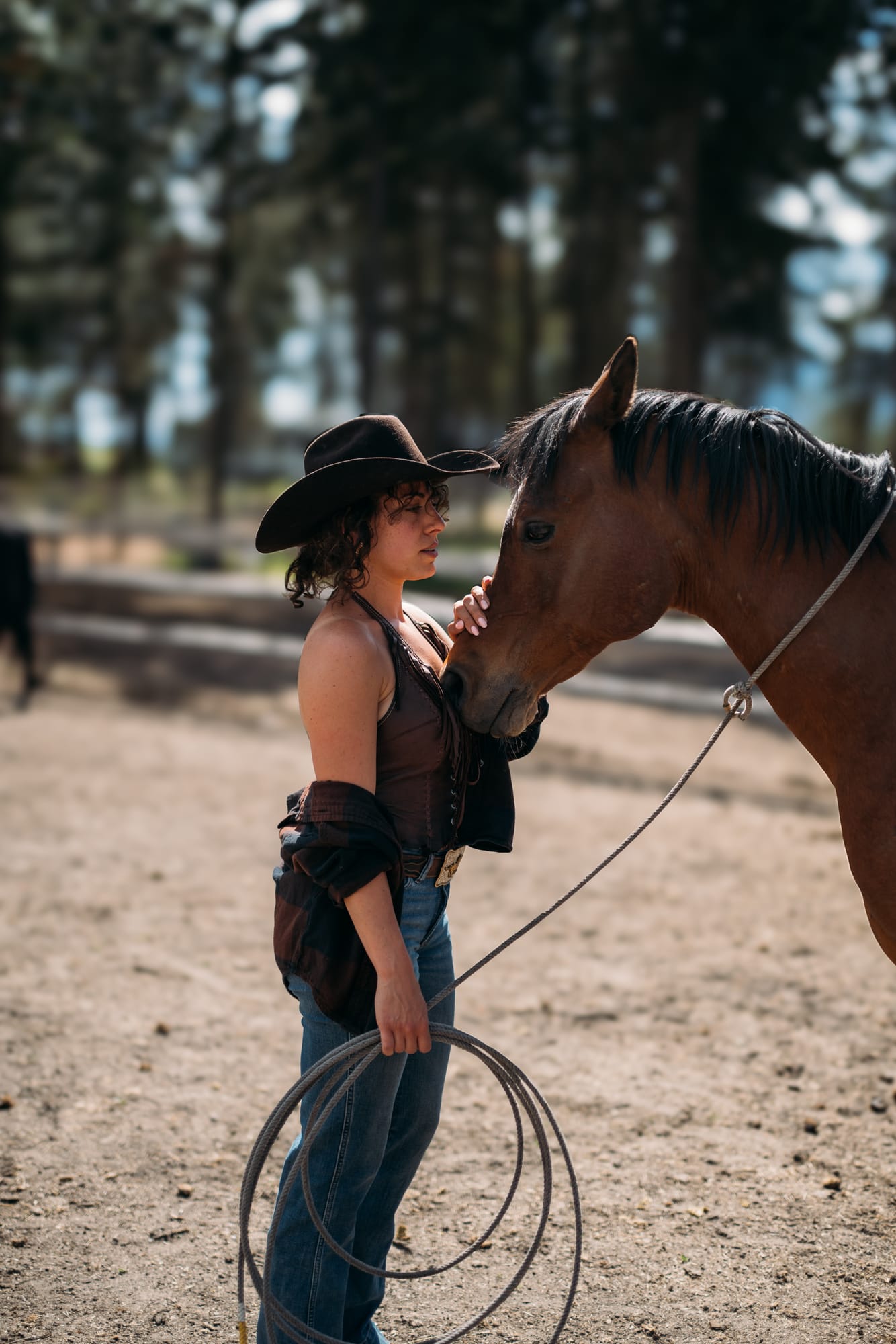 Giuliana at LoveReins portraits story frame 11: Equestrian portrait session at Love Reins Ranch in Lake Country, BC, with Giuliana, horses, white-dress portraits, Western cowgirl styling, ranch fencing, riding frames and warm Okanagan light..