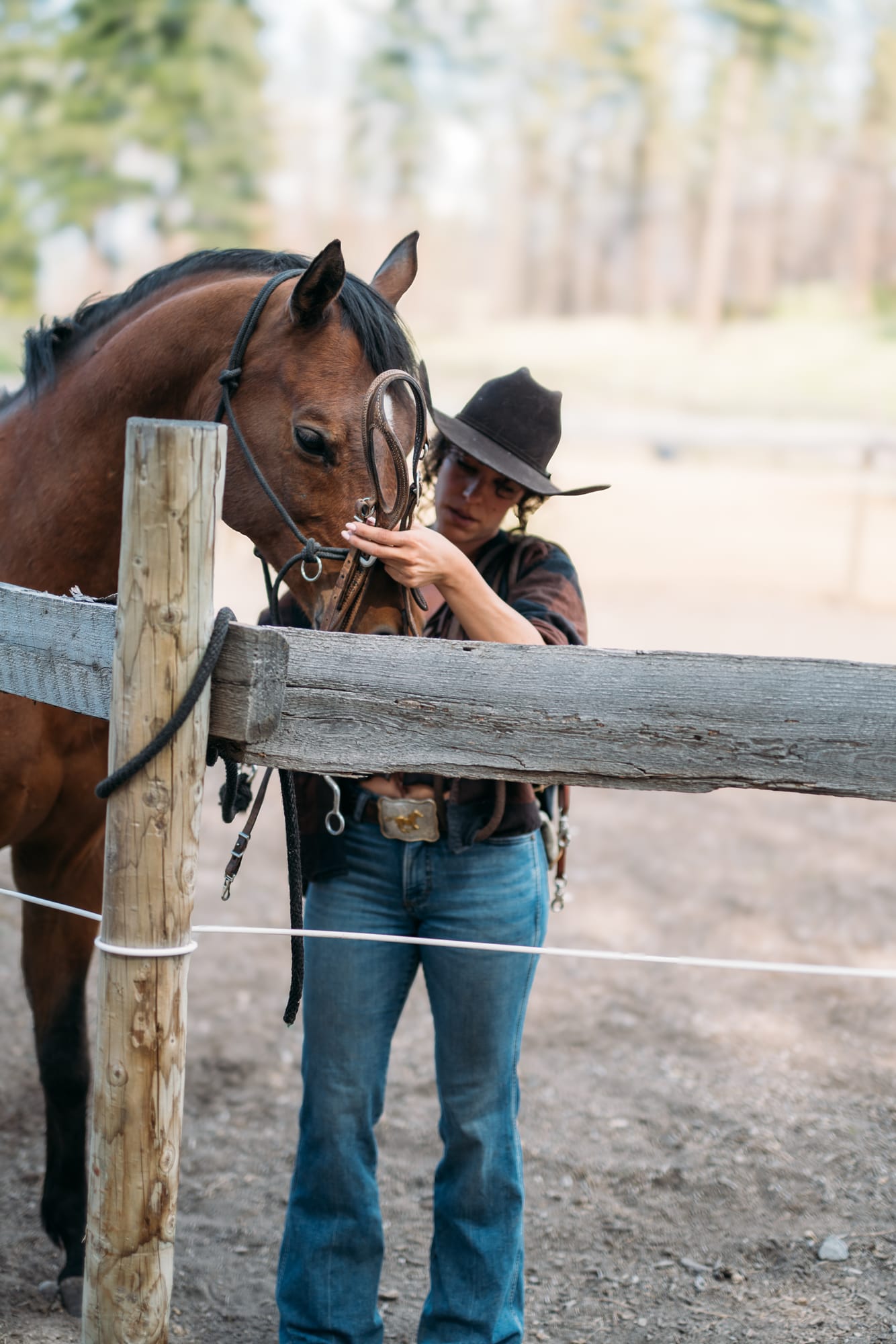 Giuliana at LoveReins portraits story frame 12: Equestrian portrait session at Love Reins Ranch in Lake Country, BC, with Giuliana, horses, white-dress portraits, Western cowgirl styling, ranch fencing, riding frames and warm Okanagan light..