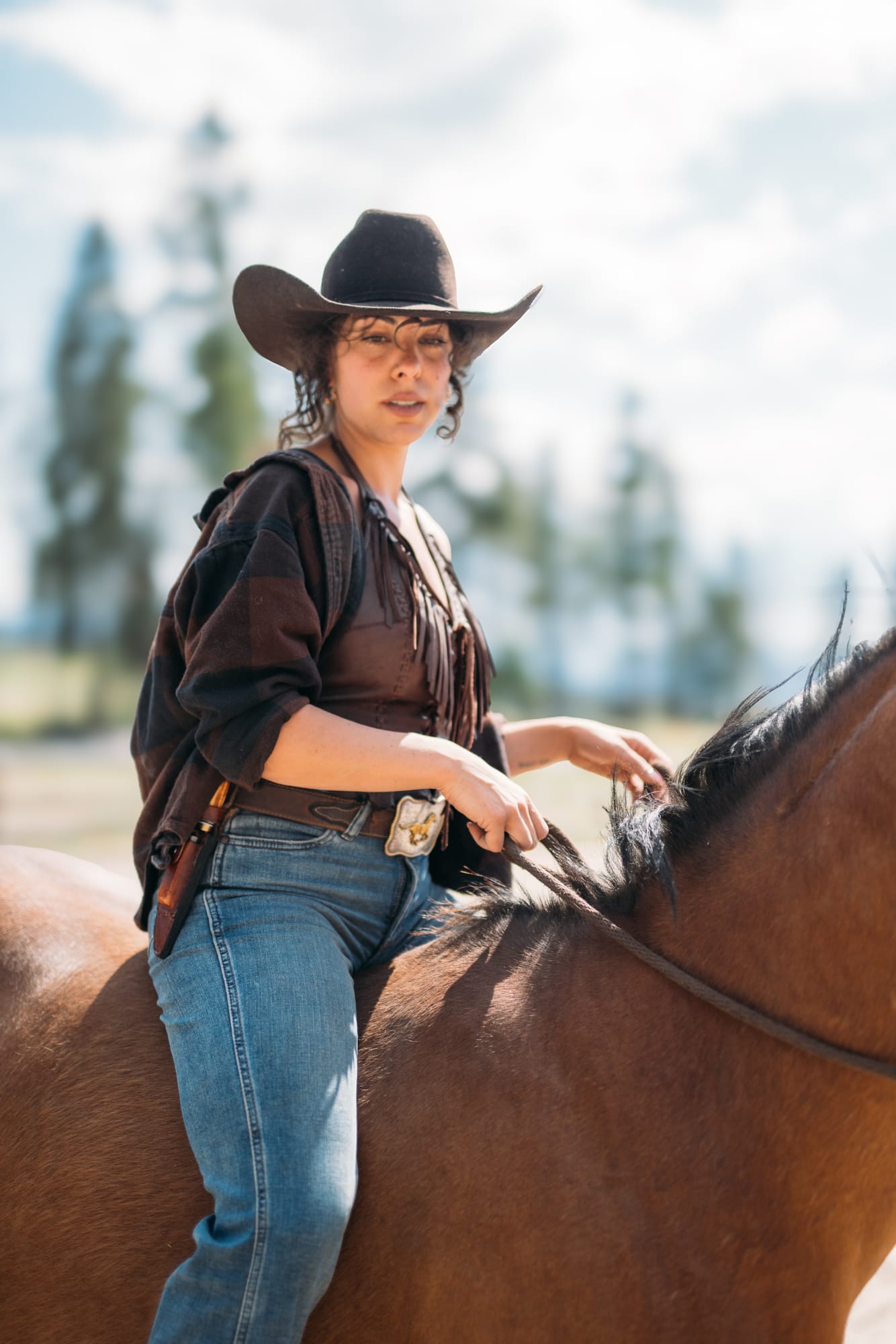 Giuliana at LoveReins portraits story frame 14: Equestrian portrait session at Love Reins Ranch in Lake Country, BC, with Giuliana, horses, white-dress portraits, Western cowgirl styling, ranch fencing, riding frames and warm Okanagan light..