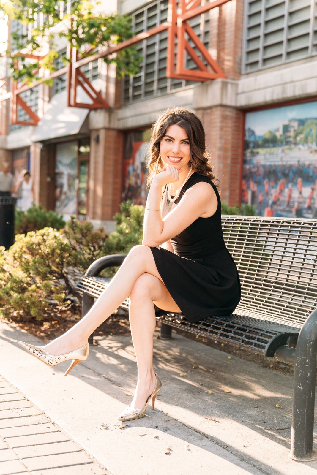 Lindsay seated on a bench in a black dress