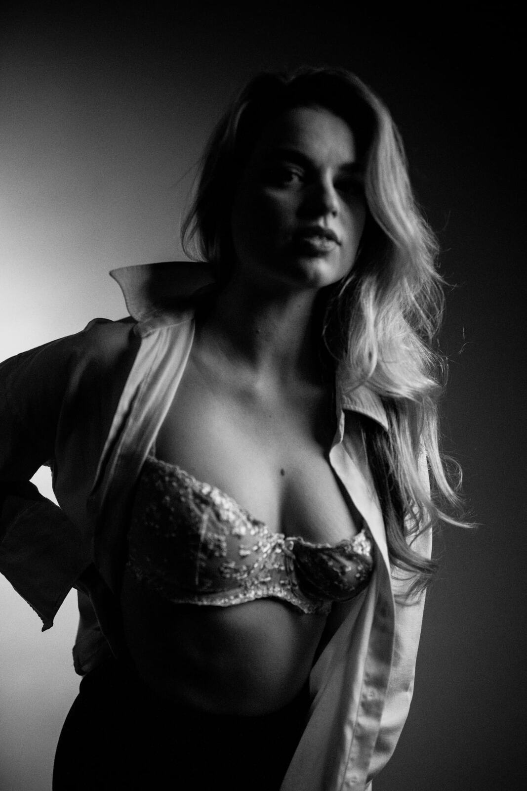 Hannah K in Black and White portraits story frame 6: A black-and-white studio portrait study with clean wardrobe shifts, close face work and controlled light.