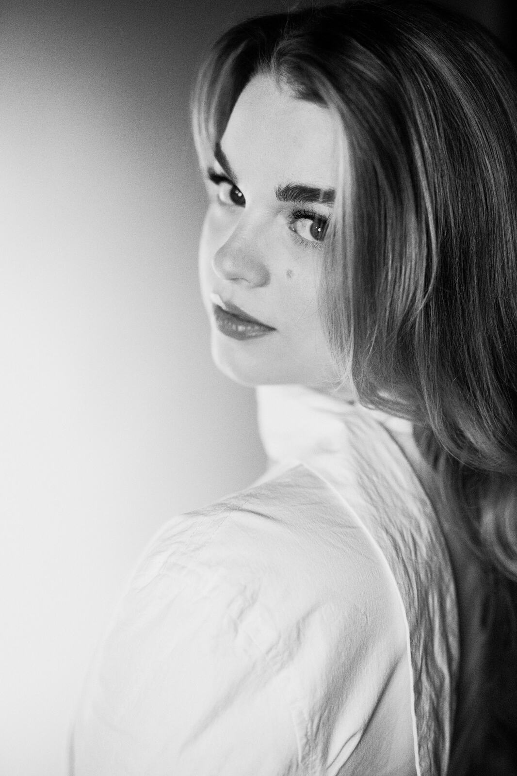 Hannah K in Black and White portraits story frame 16: A black-and-white studio portrait study with clean wardrobe shifts, close face work and controlled light.