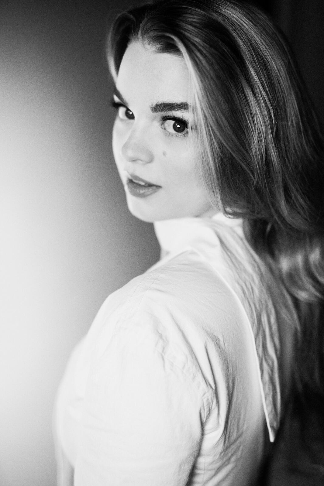 Hannah K in Black and White portraits story frame 17: A black-and-white studio portrait study with clean wardrobe shifts, close face work and controlled light.