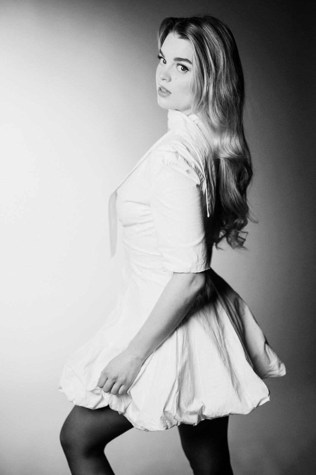 Hannah K in Black and White portraits story frame 10: A black-and-white studio portrait study with clean wardrobe shifts, close face work and controlled light.
