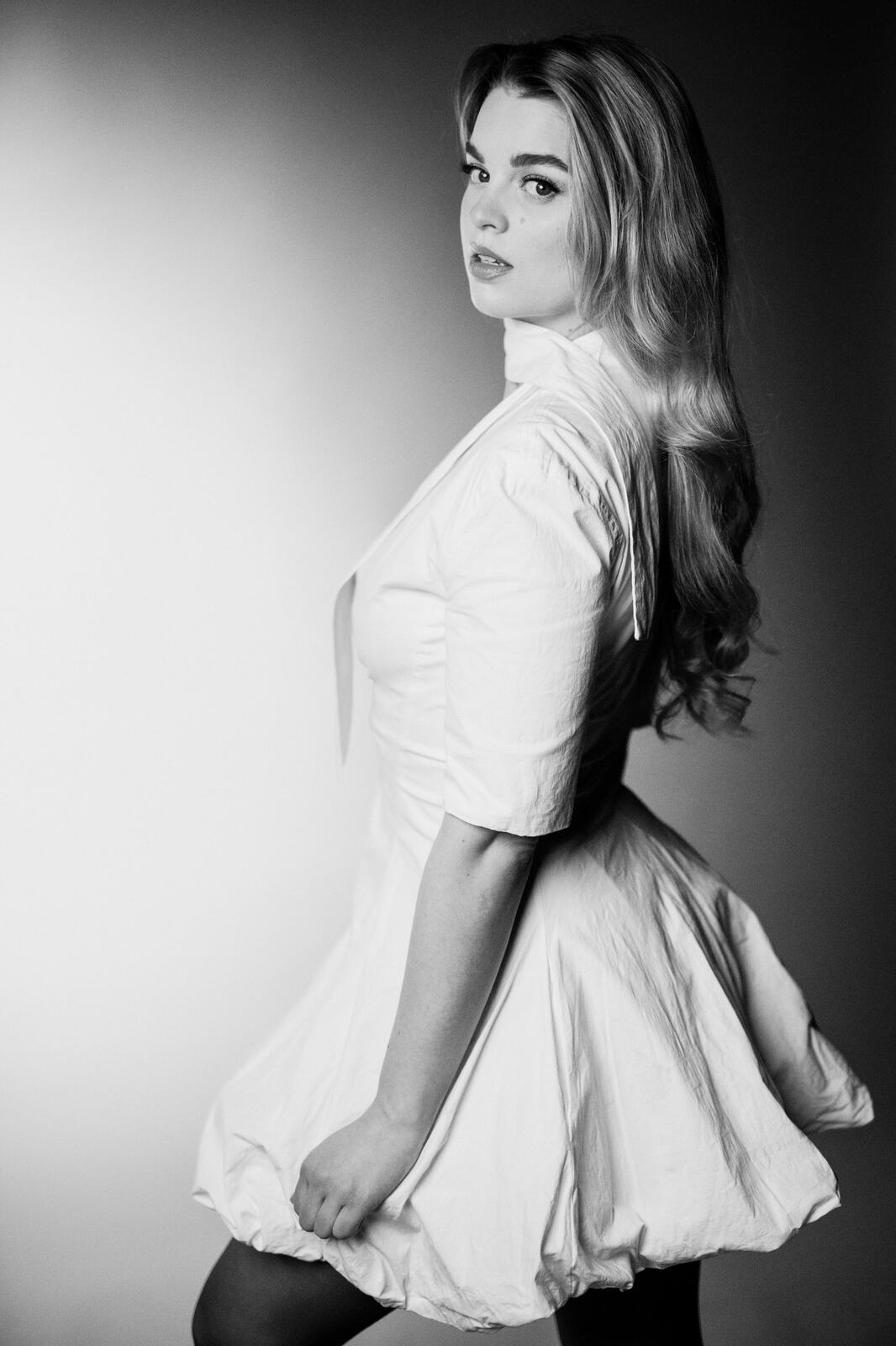 Hannah K in Black and White portraits story frame 11: A black-and-white studio portrait study with clean wardrobe shifts, close face work and controlled light.