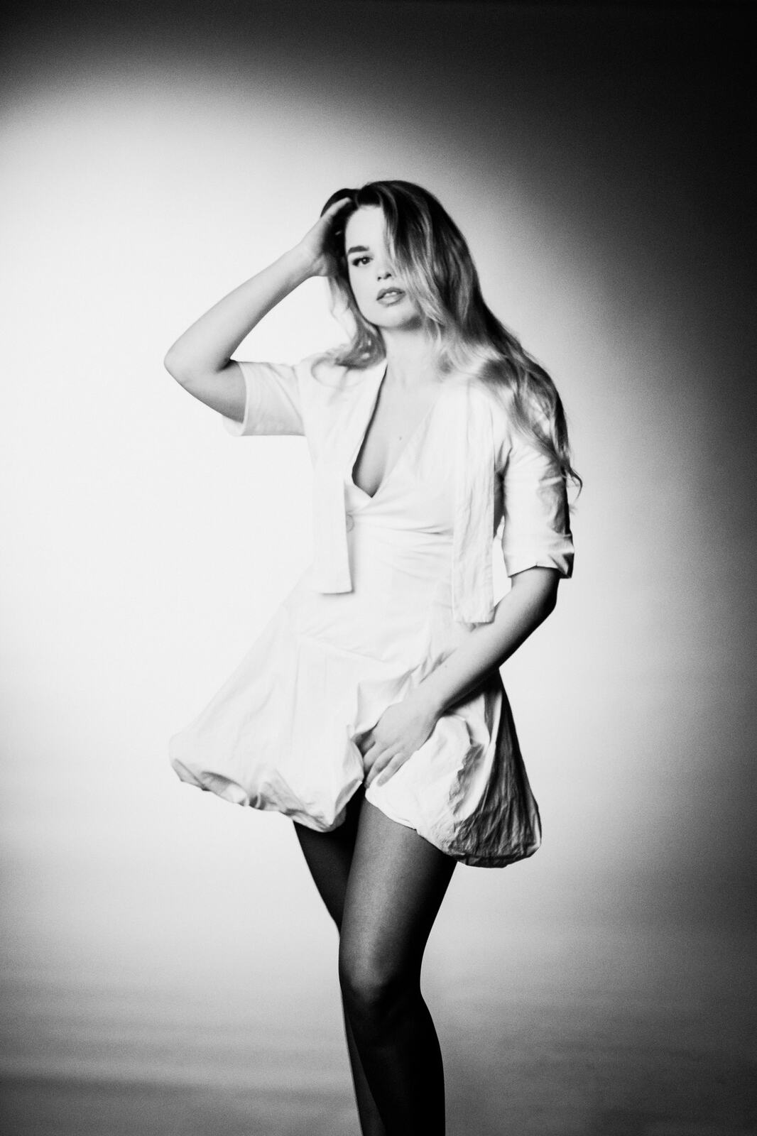 Hannah K in Black and White portraits story frame 1: A black-and-white studio portrait study with clean wardrobe shifts, close face work and controlled light.