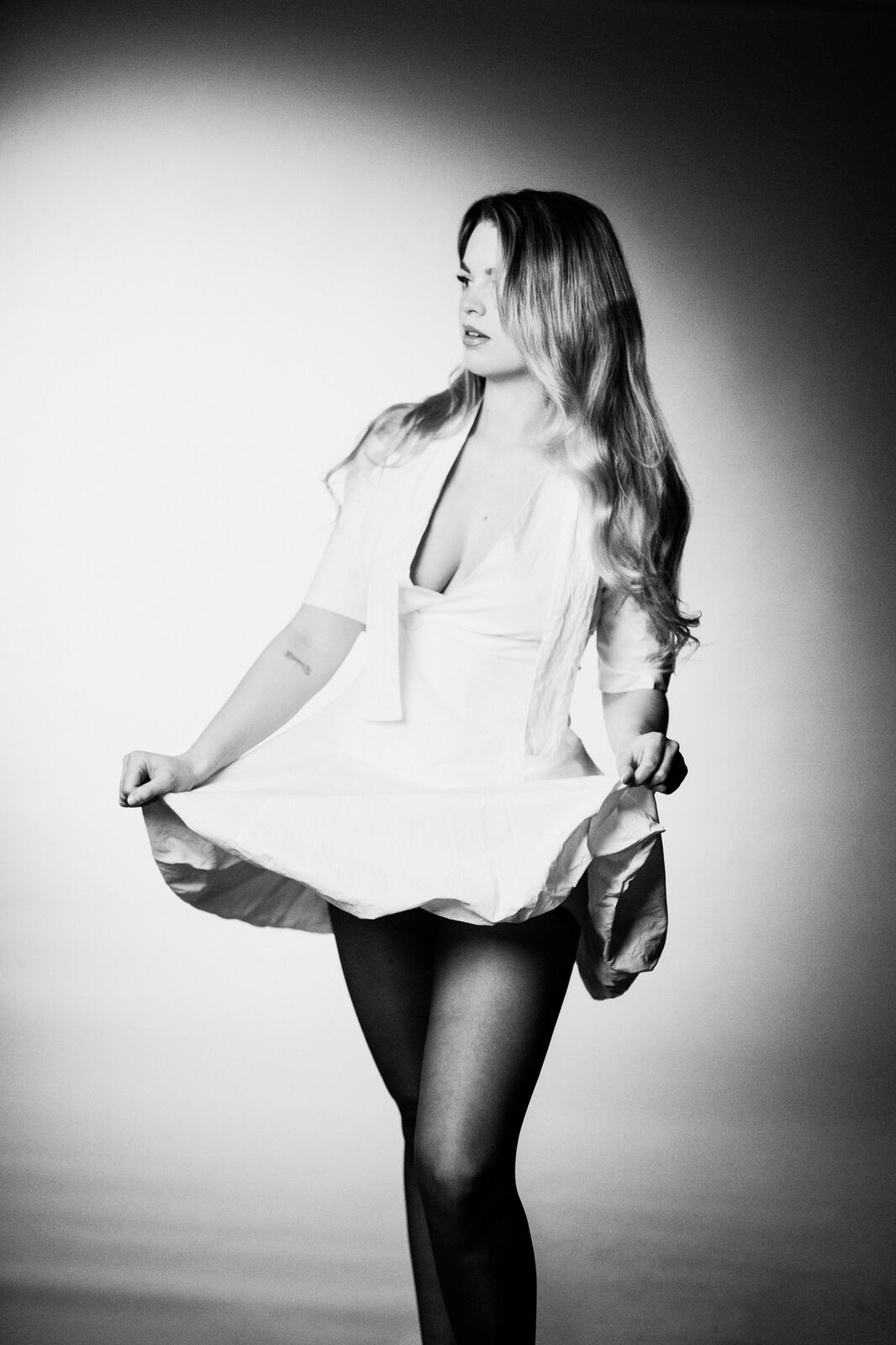Hannah K in Black and White portraits story frame 2: A black-and-white studio portrait study with clean wardrobe shifts, close face work and controlled light.