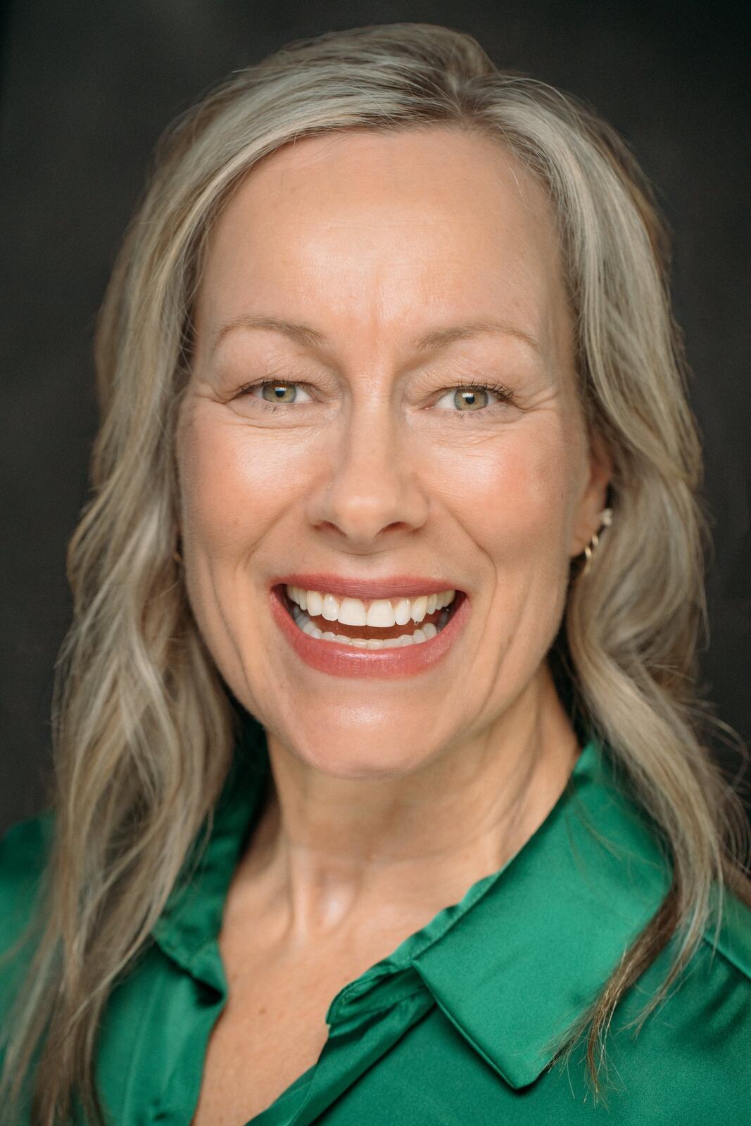 Shaye smiling in a bright green blouse