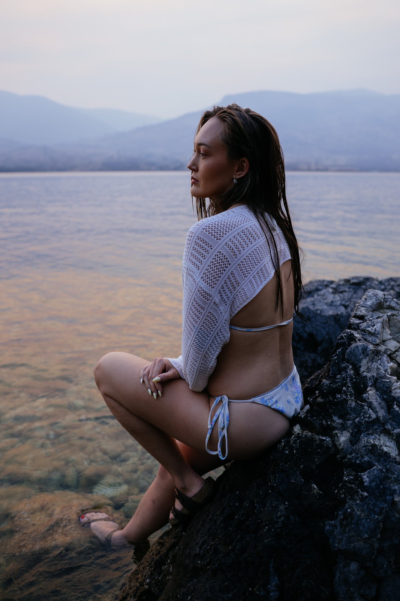 Holly — a soft smile while seated on a rock