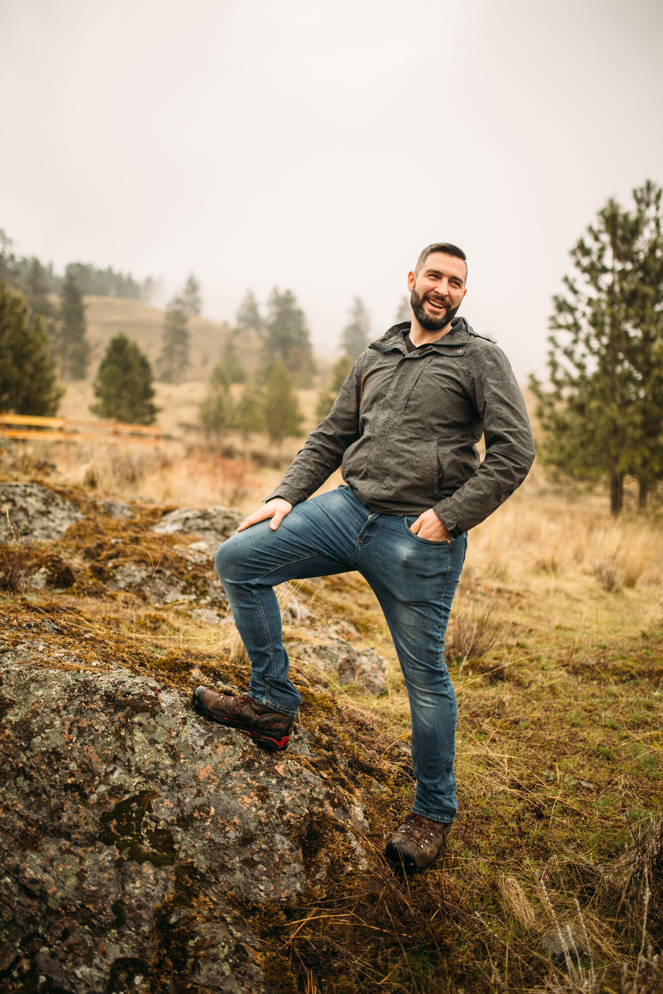 Vertical portrait of Jeremy seated among tall grass at Knox Mountain.