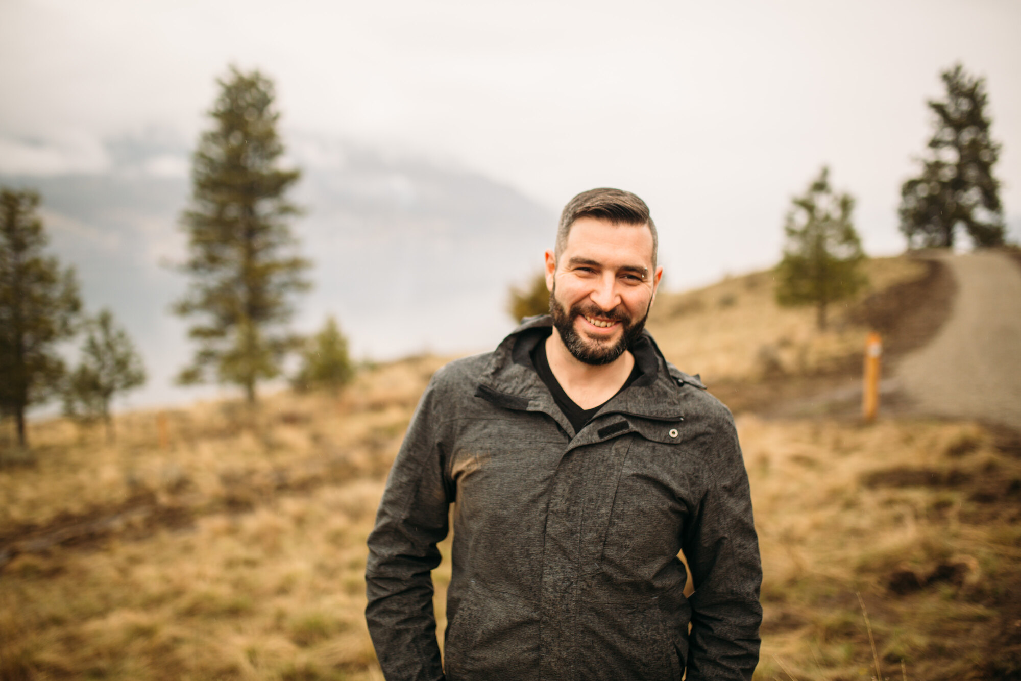 Three-quarter portrait of Jeremy framed by grass and distant water.
